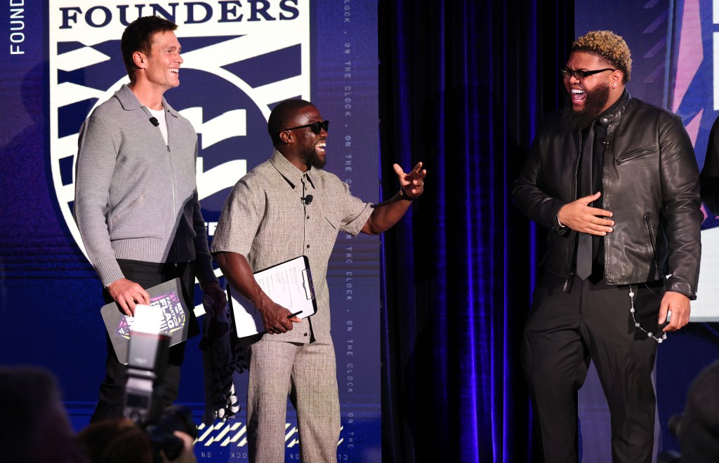 Tom Brady, Kevin Hart, and an unidentified person laughing on stage at the Fanatics Flag Football Classic Draft.