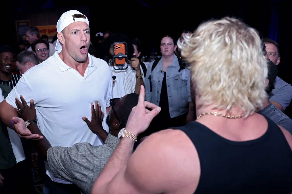 Rob Gronkowski looking surprised while another man points his finger at him.