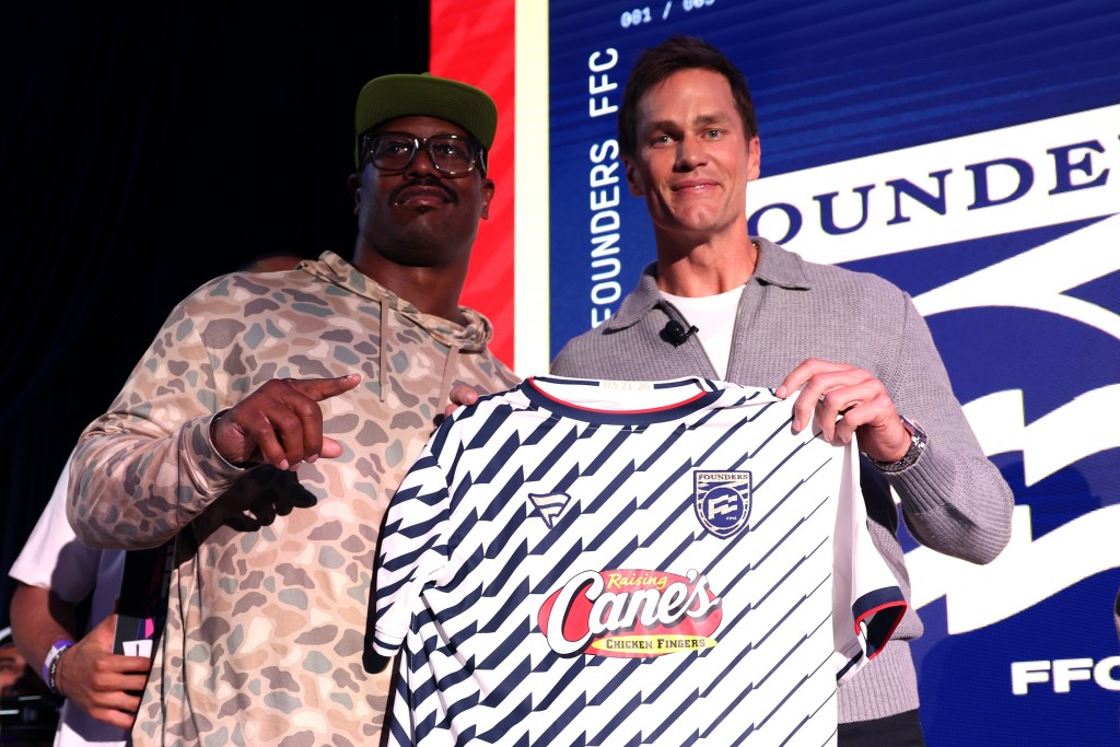 Two men holding a jersey for the Fanatics Flag Football Classic.
