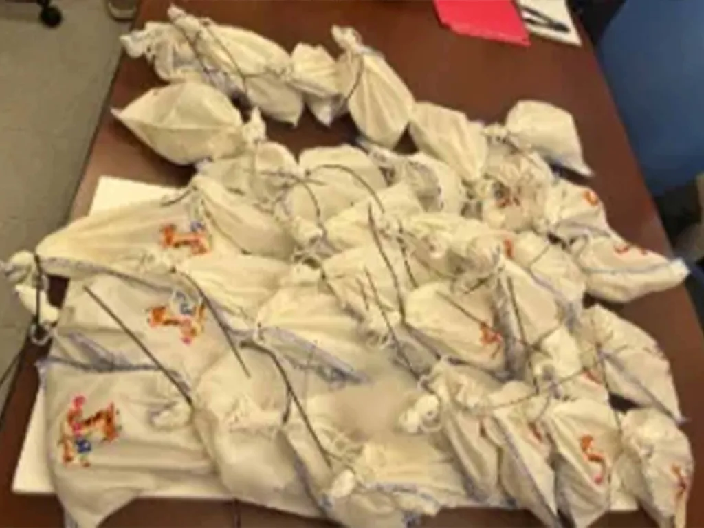 Bundles of pythons wrapped in white cloth on a brown surface.