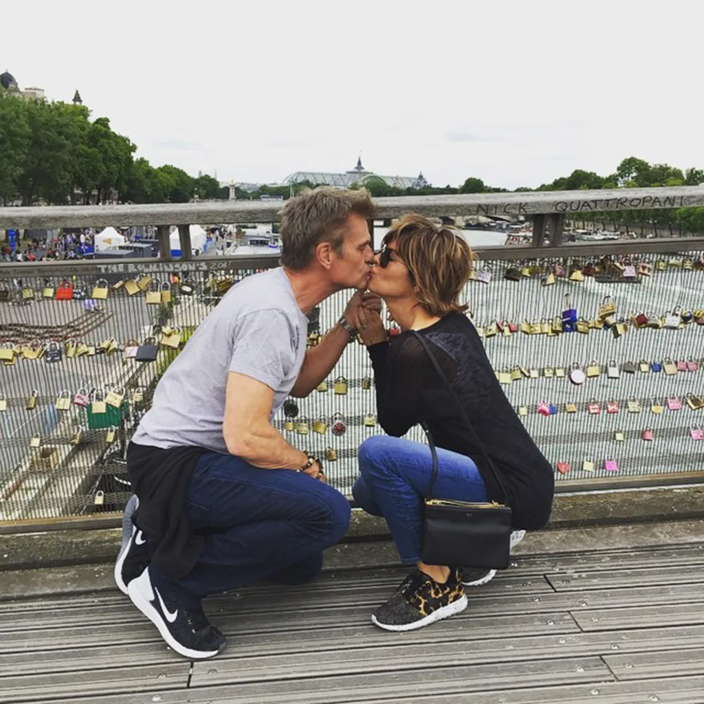 A couple kissing on the Pont des Arts bridge in Paris, adorned with love locks.