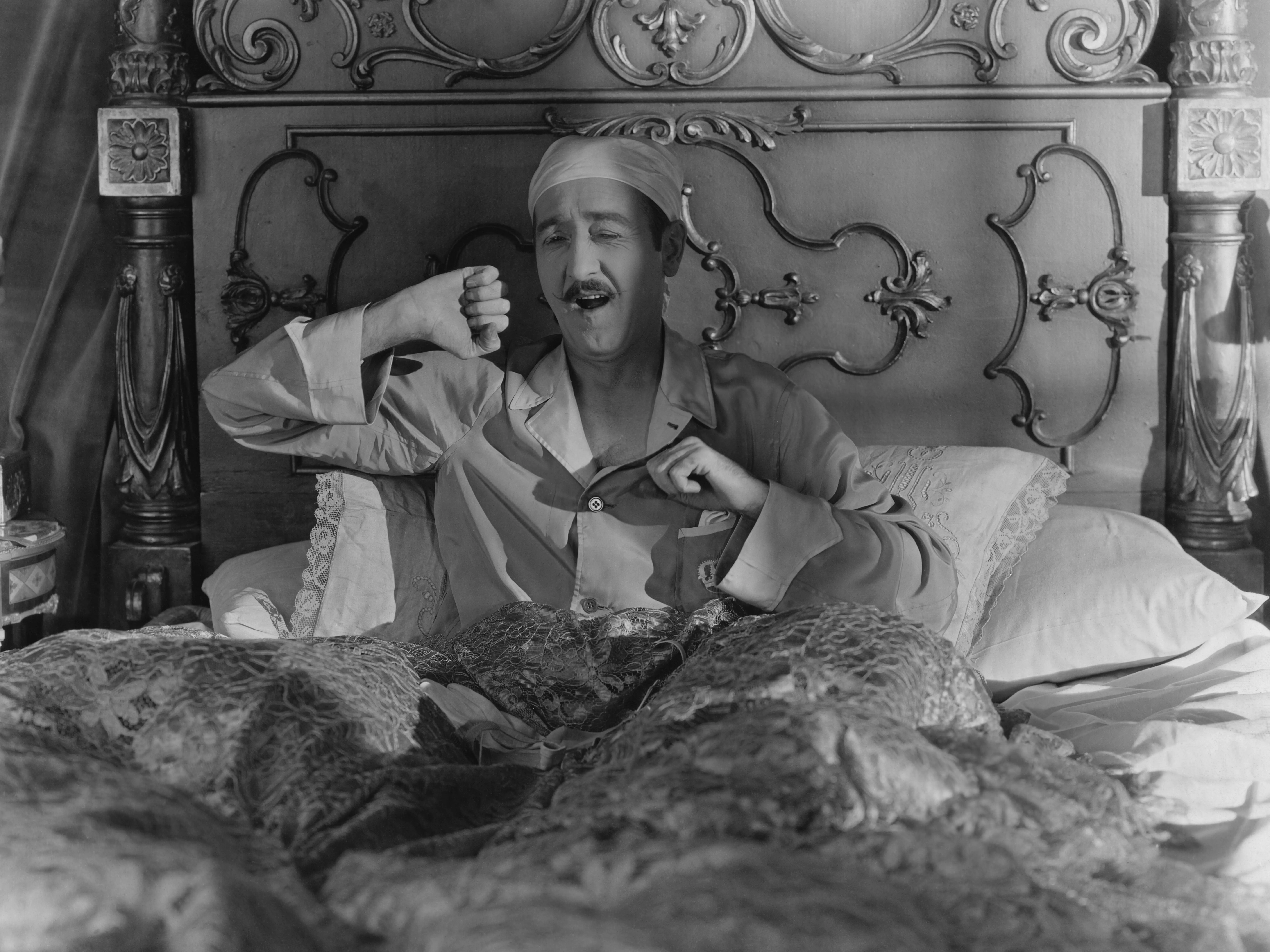 A man yawning in bed.