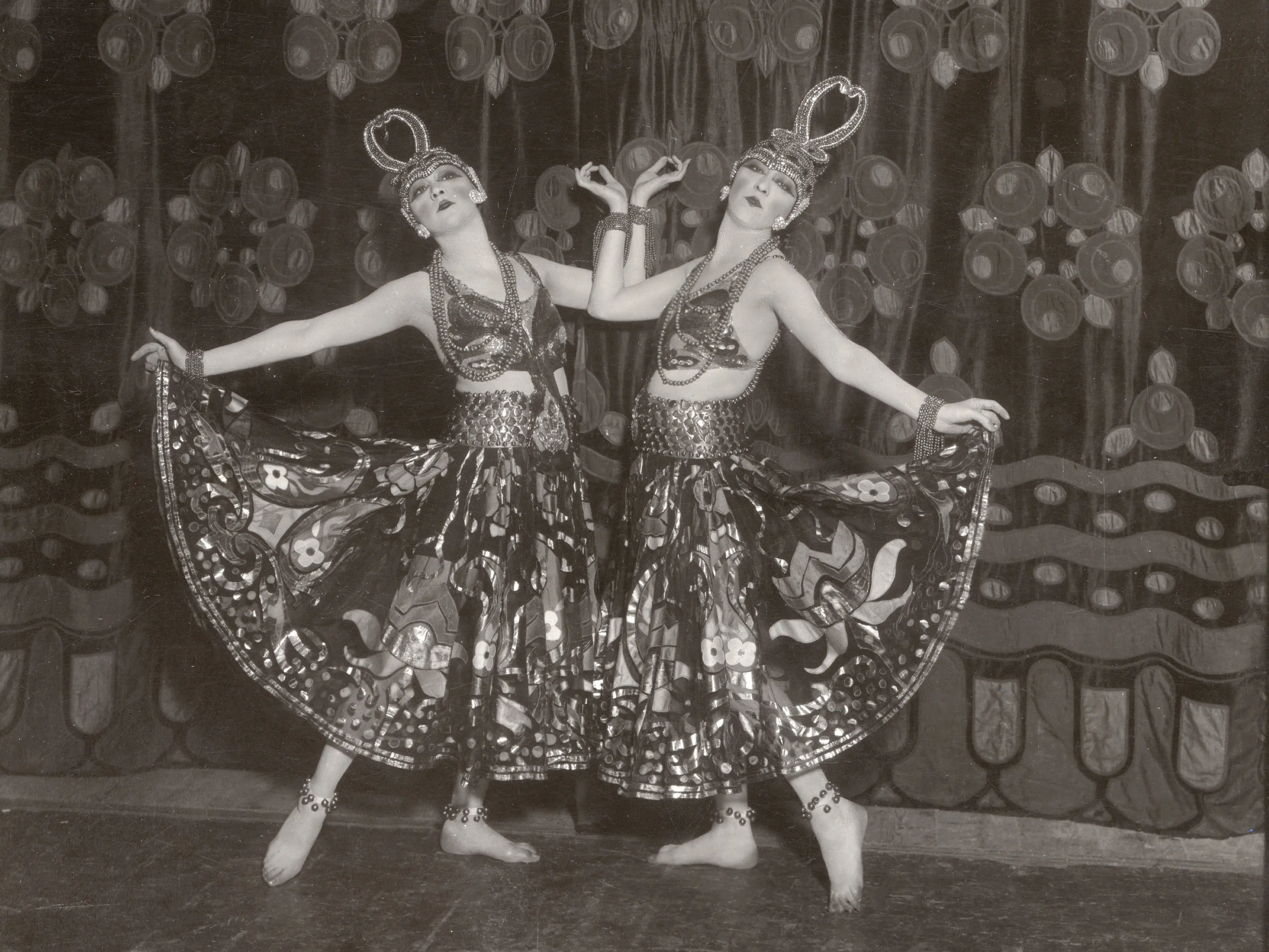 The Dolly Sisters on stage in the 1920s. They wore elaborate, detailed costumes and headpieces.