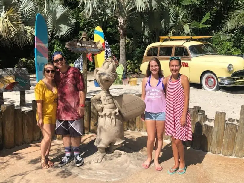 kayleigh and friends posing with the sand mascot of typhoon lagoon water park at disney world