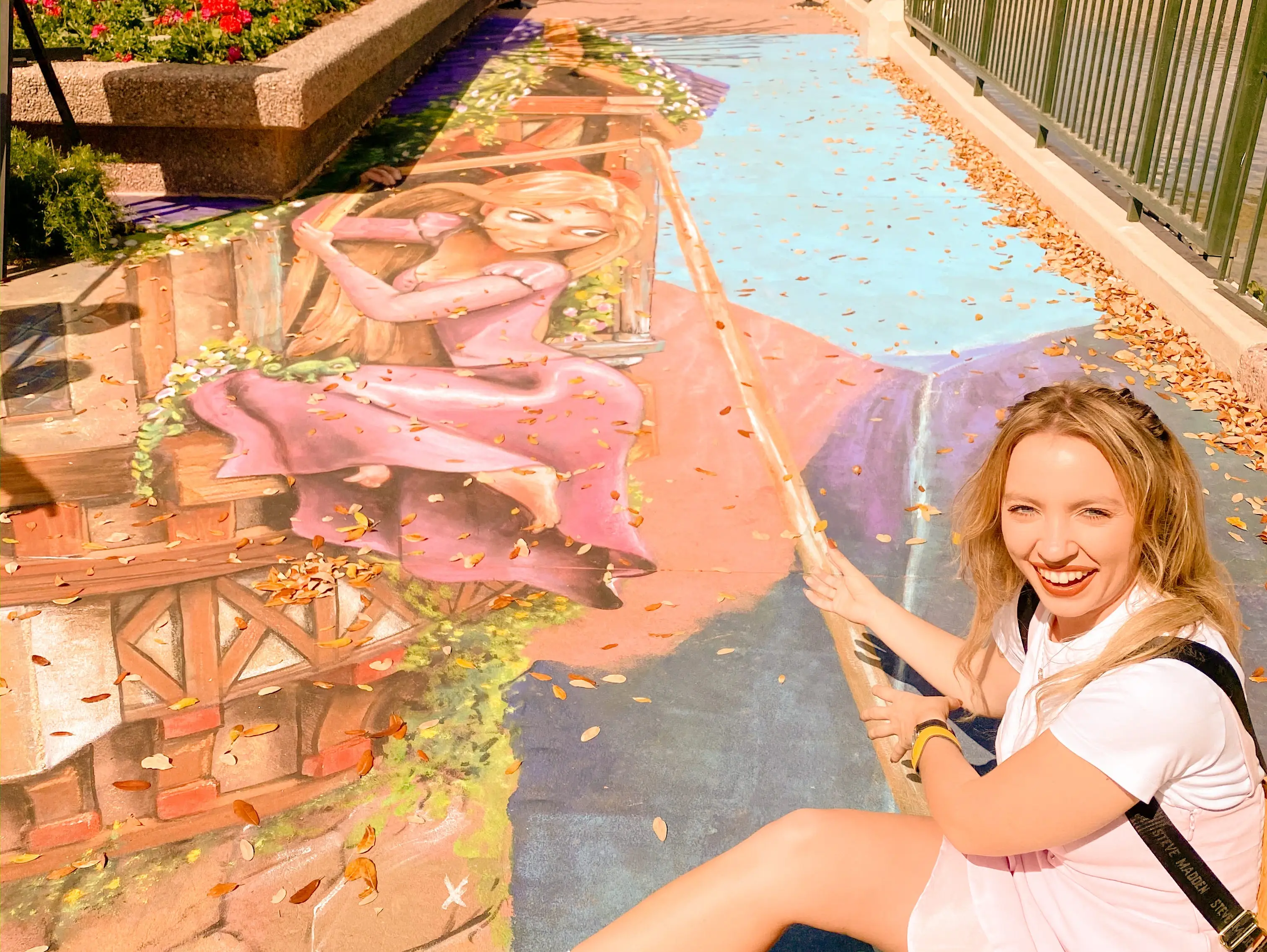kayleigh posing next to a rapunzel themed chalk mural at epcot festival of the arts
