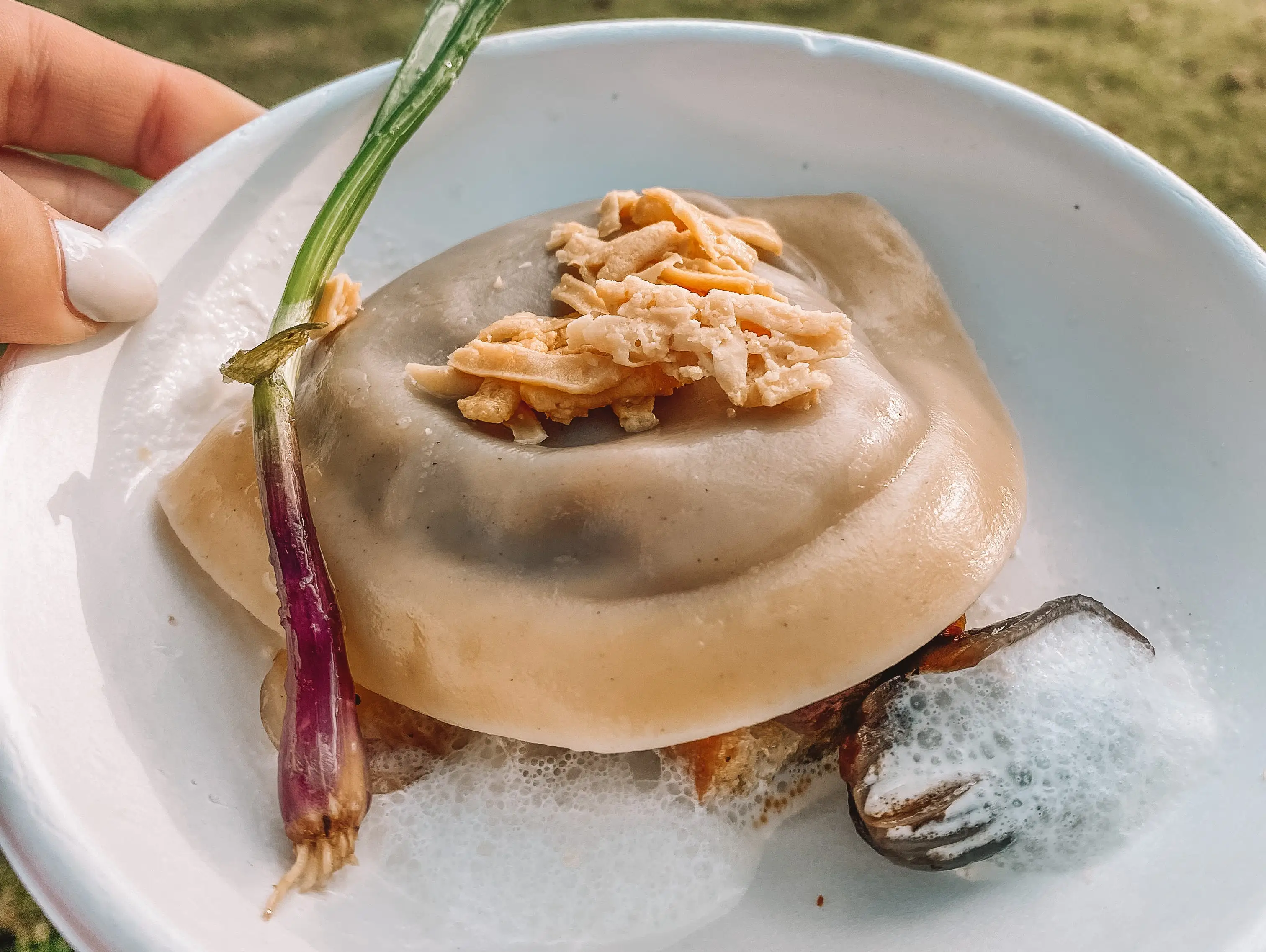 hand holding a plate of deconstructed french onion soup from epcot festival of the arts