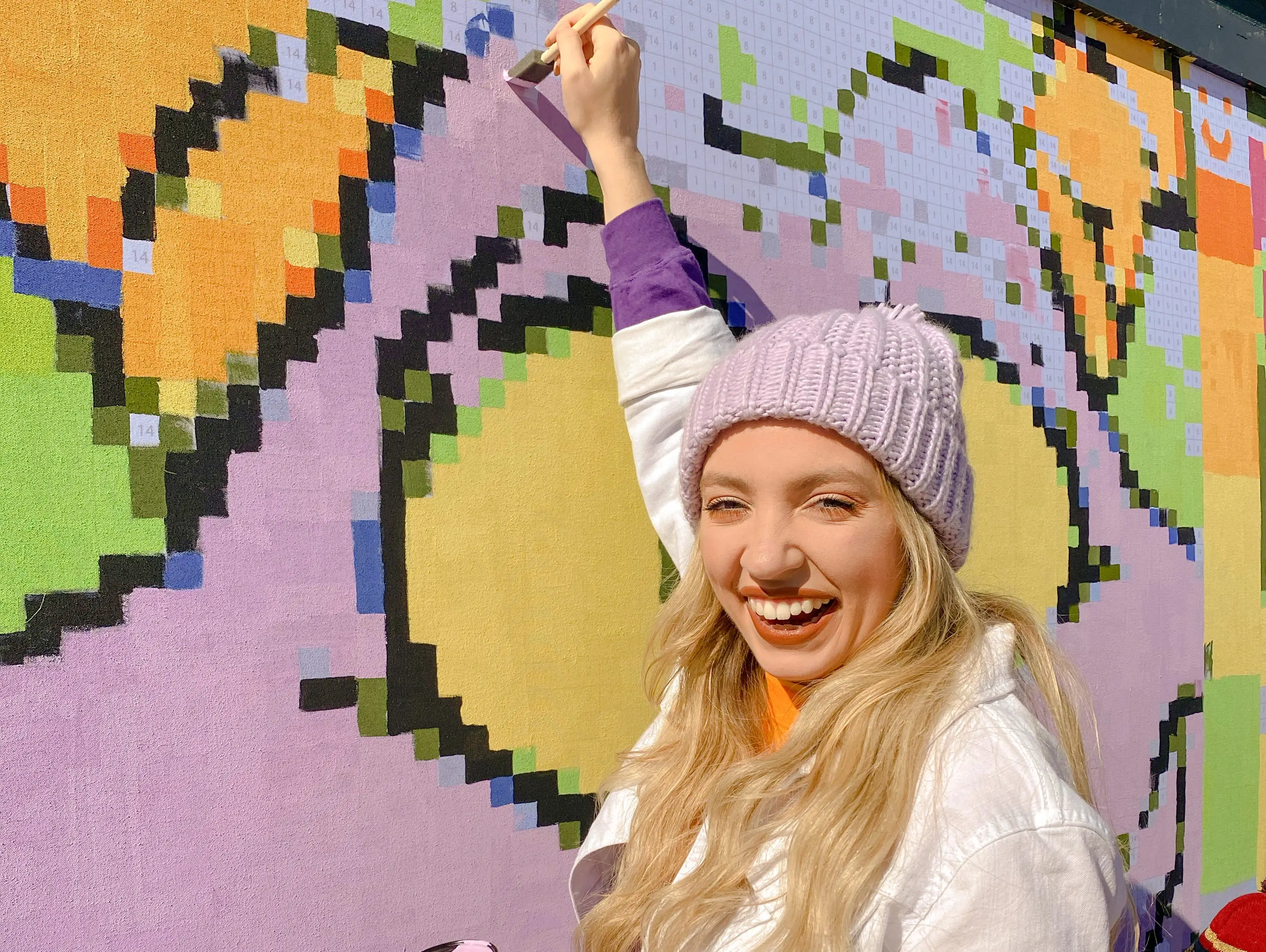 kayleigh painting a paint by numbers mural of figment at epcot