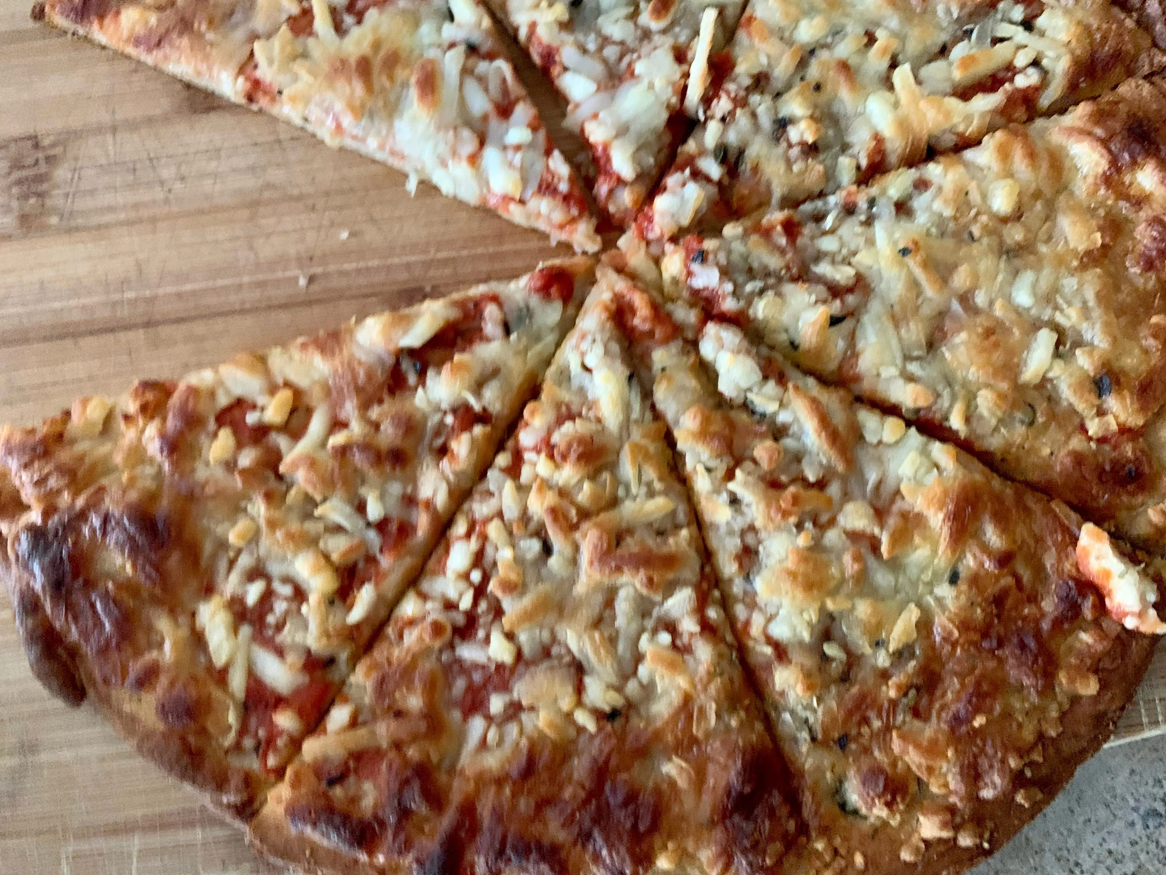 several slices of Trader Joe's cheese cauliflower pizza on cutting board