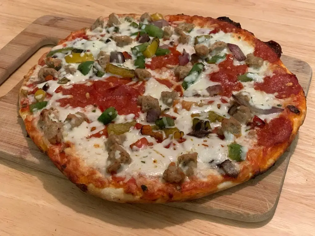 cooked Trader joe's parlanno pizza on cutting board
