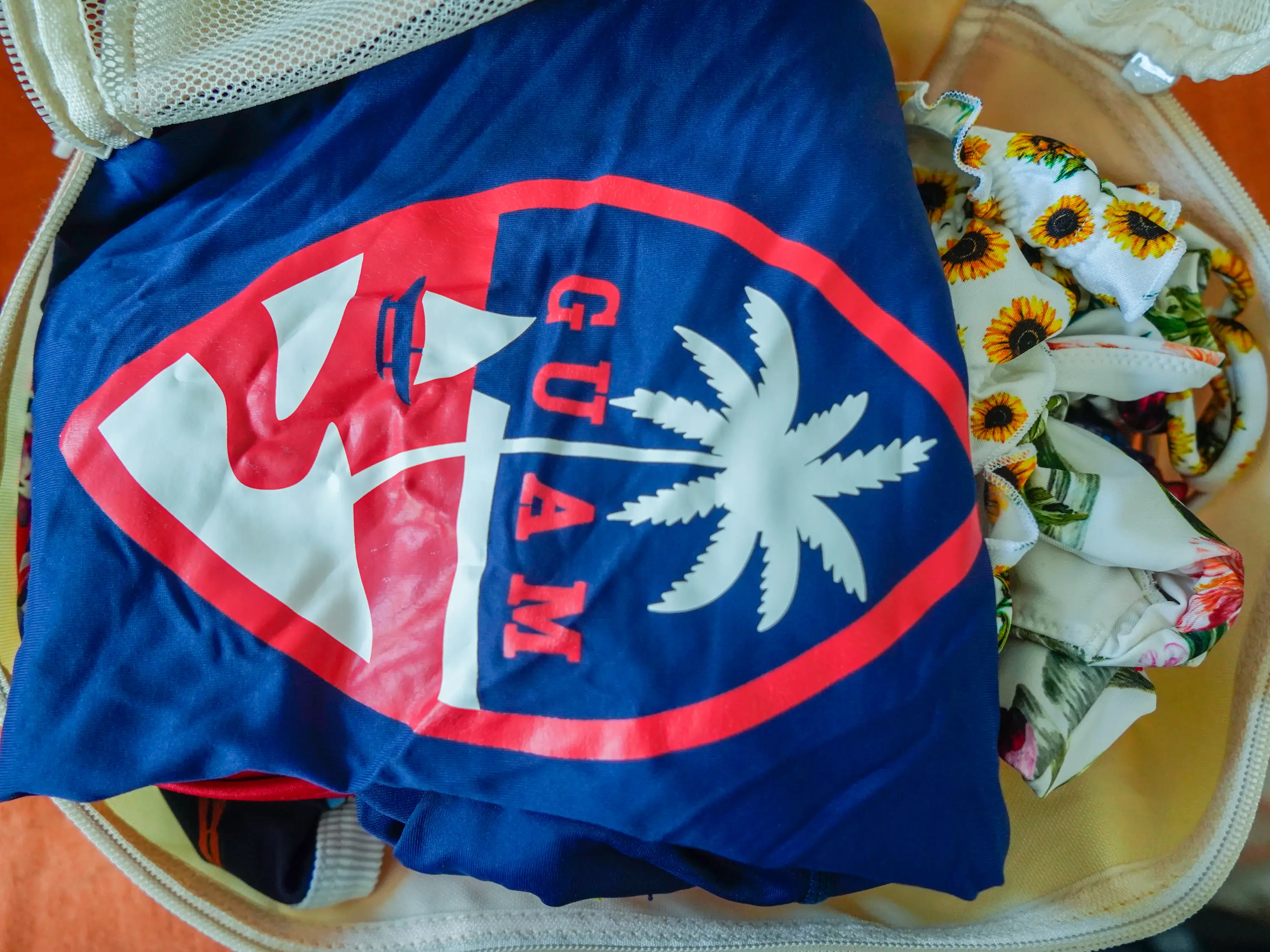 The author's rash guard and bathing suits inside an open packing cube