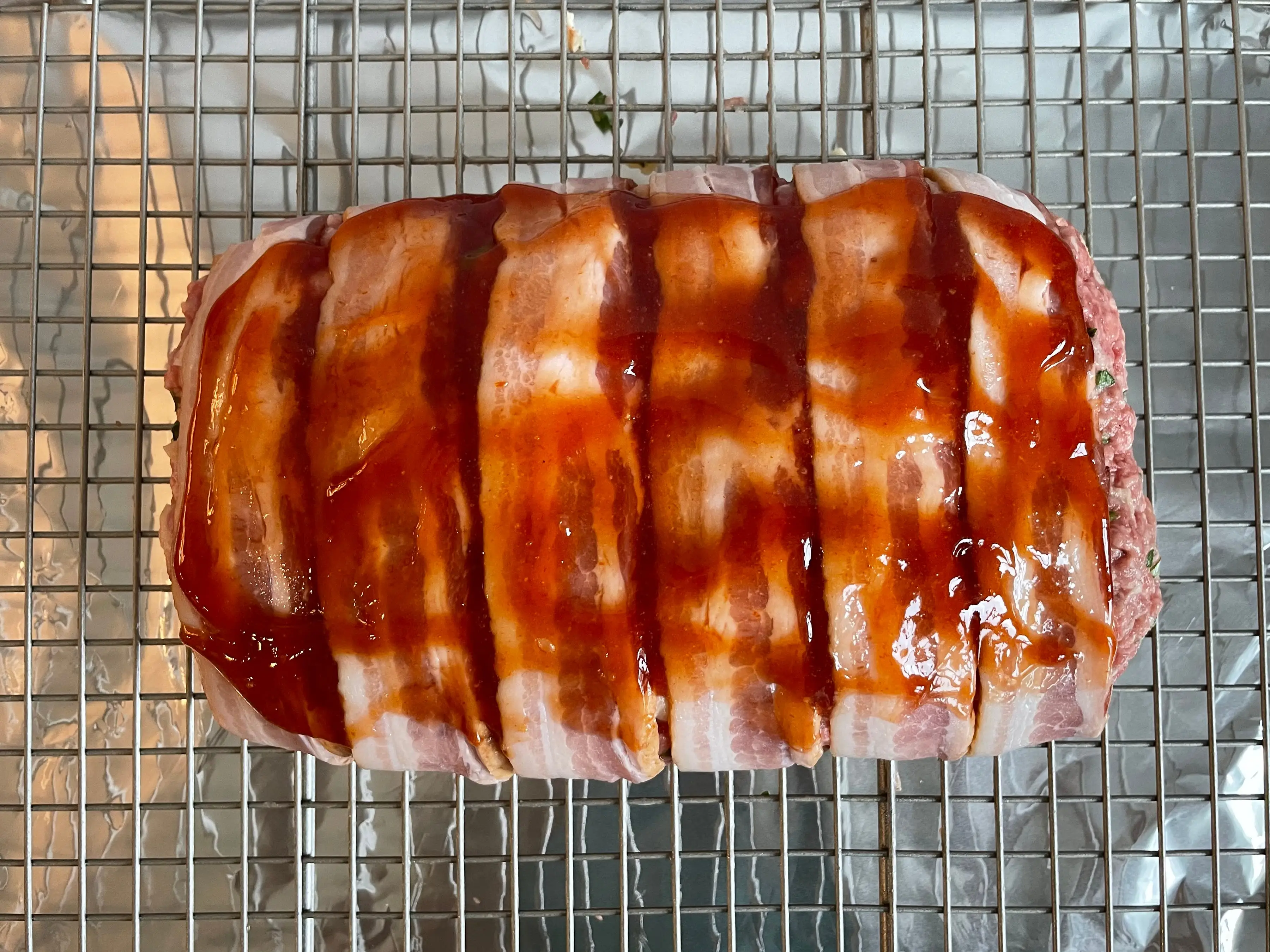 Meat loaf covered in bacon and barbecue sauce.