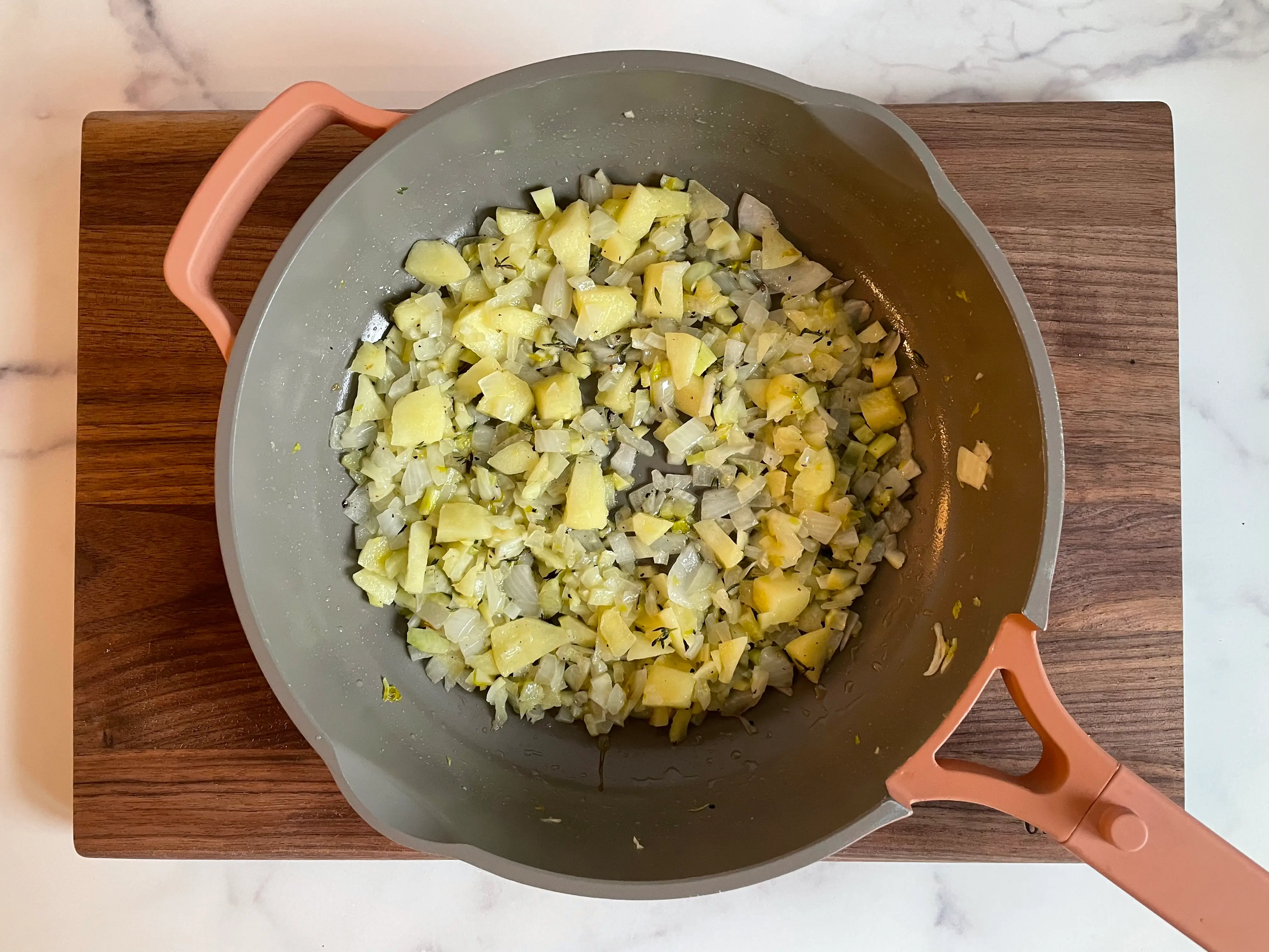 Sautéed vegetables and spices on a stove.
