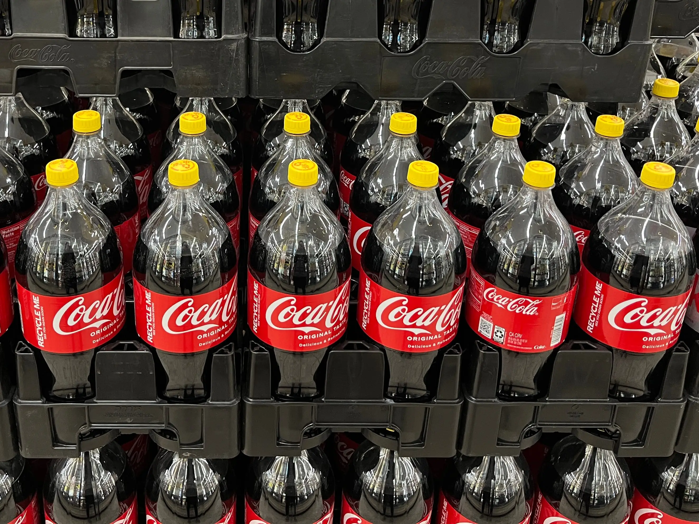 Coca-Cola bottles with yellow caps.