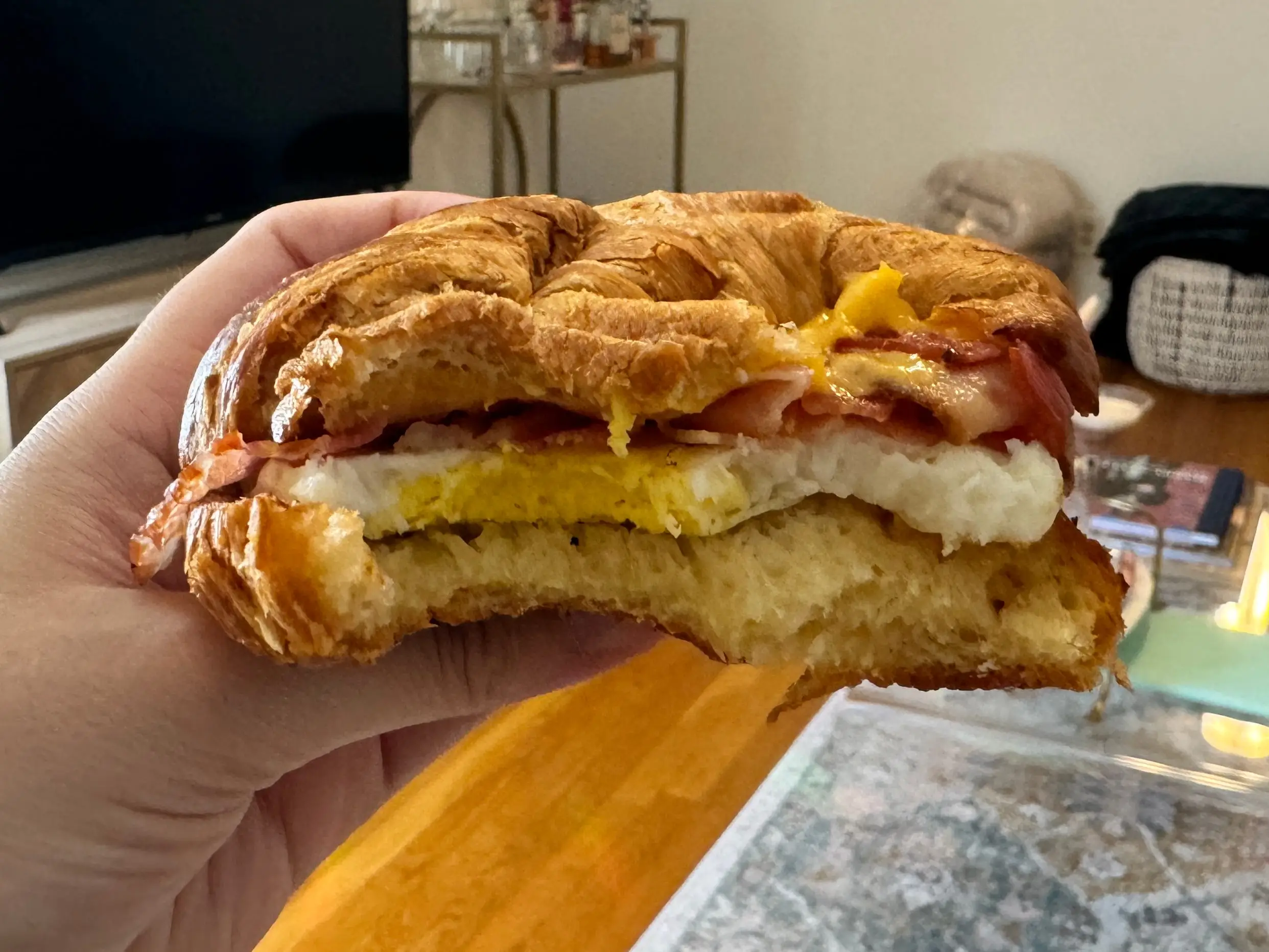 bacon egg cheese sandwich from dunkin with a bite taken out of it