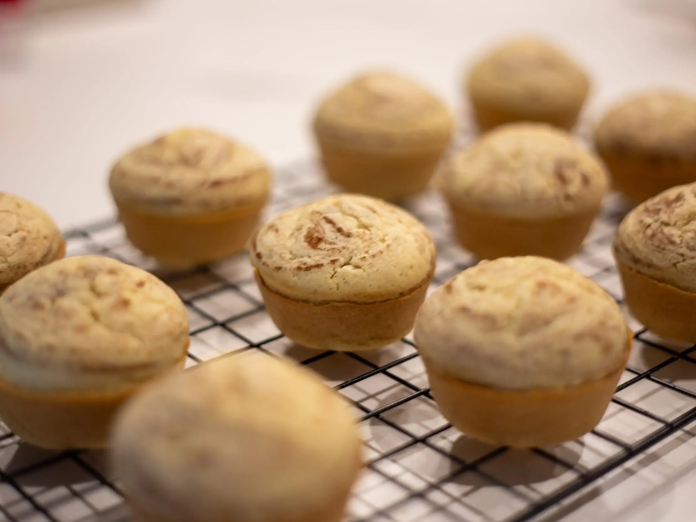 Freshly baked muffins on a baking rack.