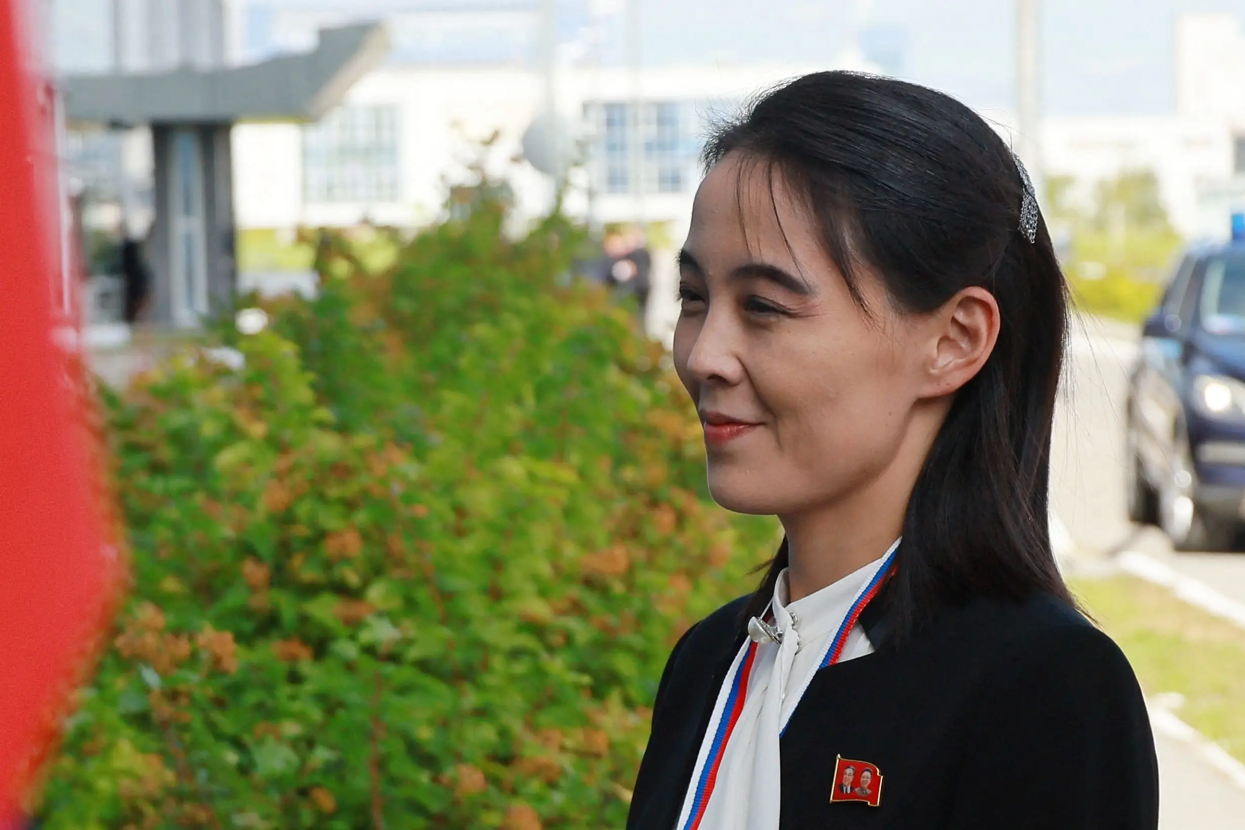 Kim Yo Jong smiles wearing a navy jacket over a white shirt