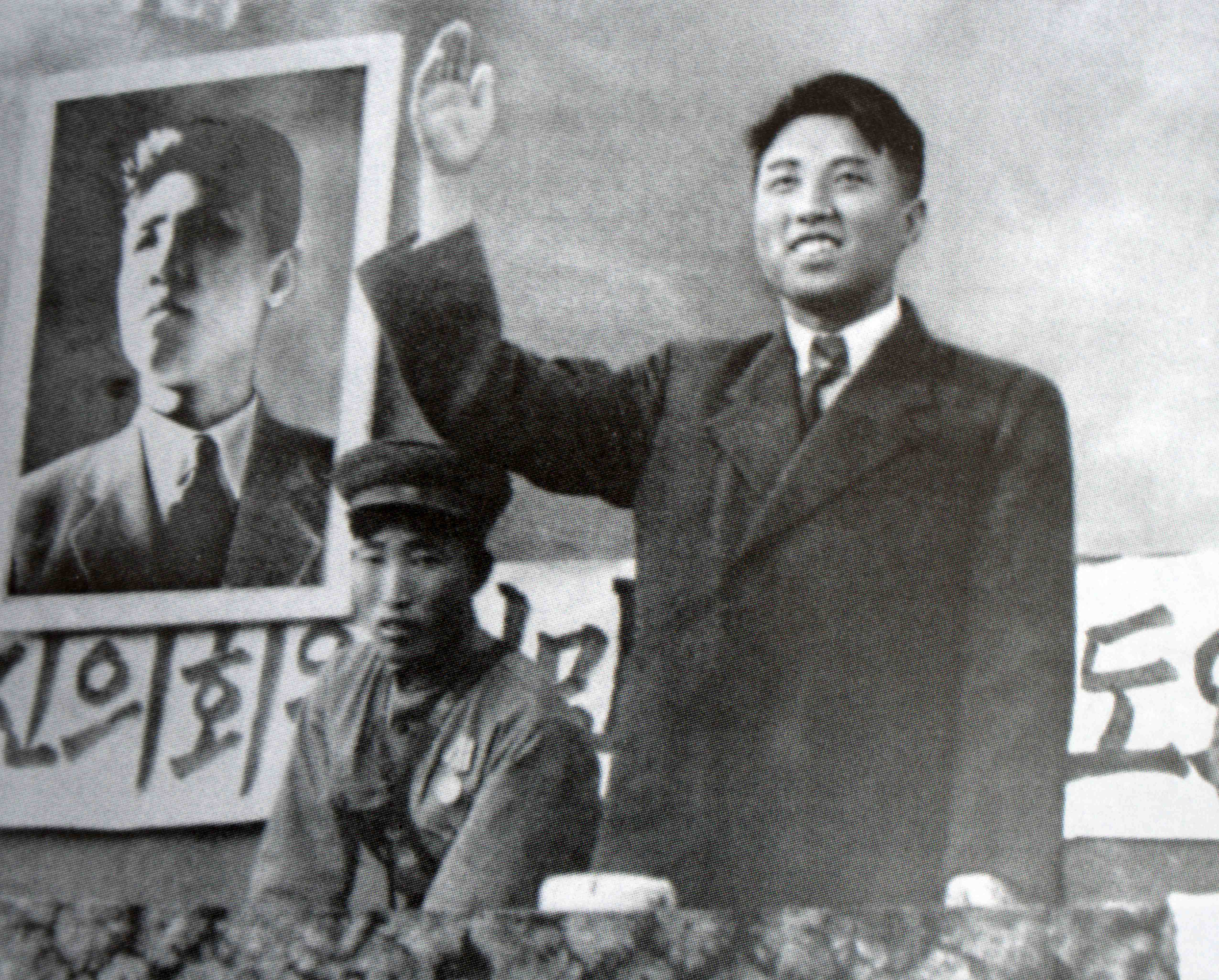 Kim Il Sung waves while wearing a suit at a rally
