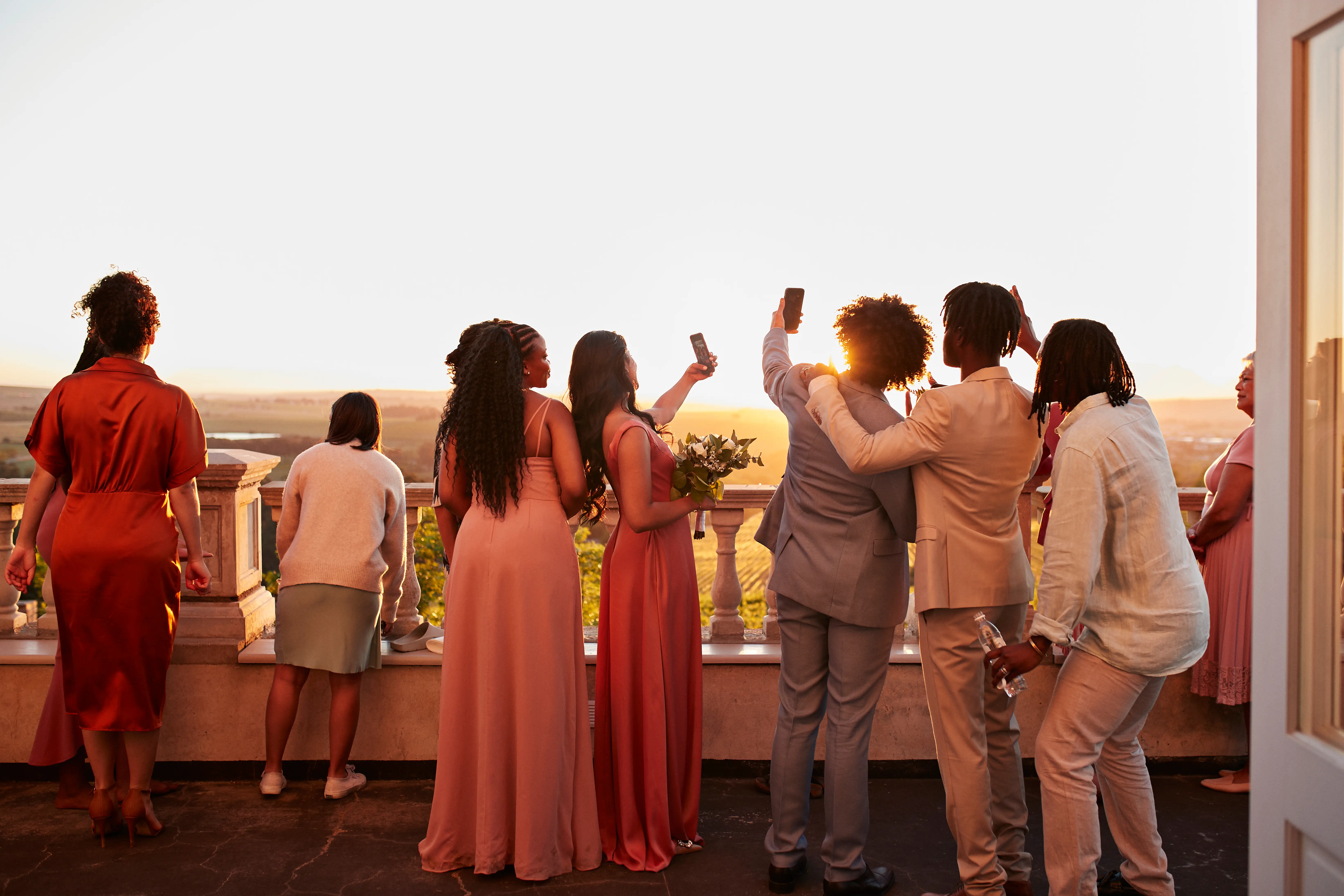Guests taking selfies at wedding at sunset