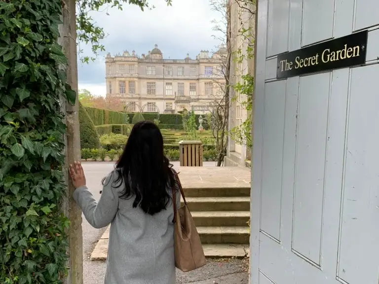 The writer poses in front of the doorway to a garden in the UK.