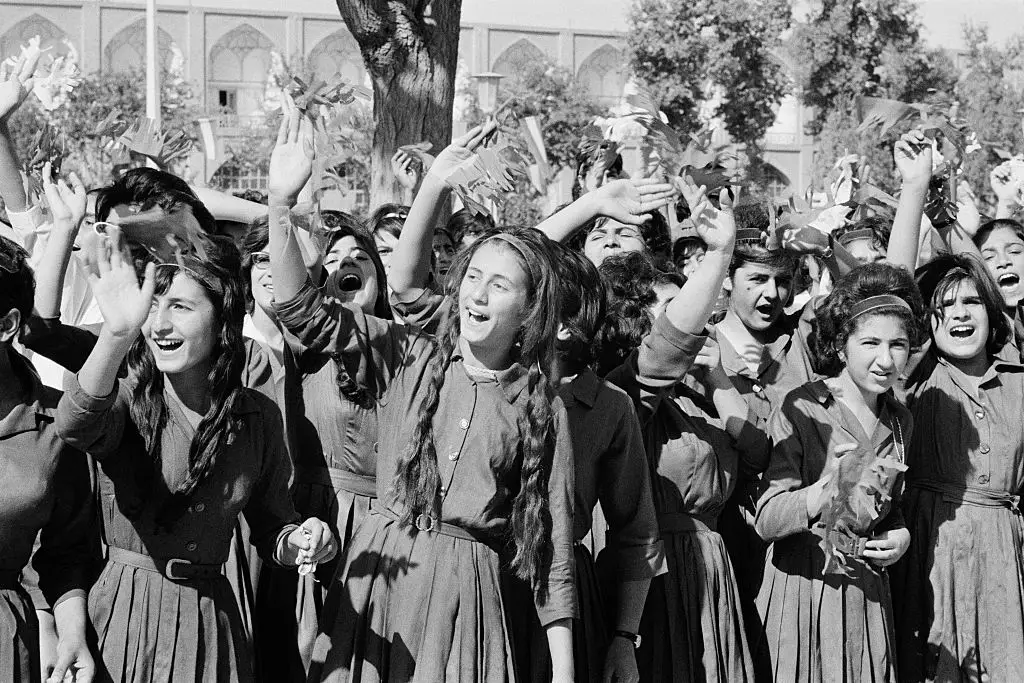 Women in Tehran wave at French President Charles de Gaulle.