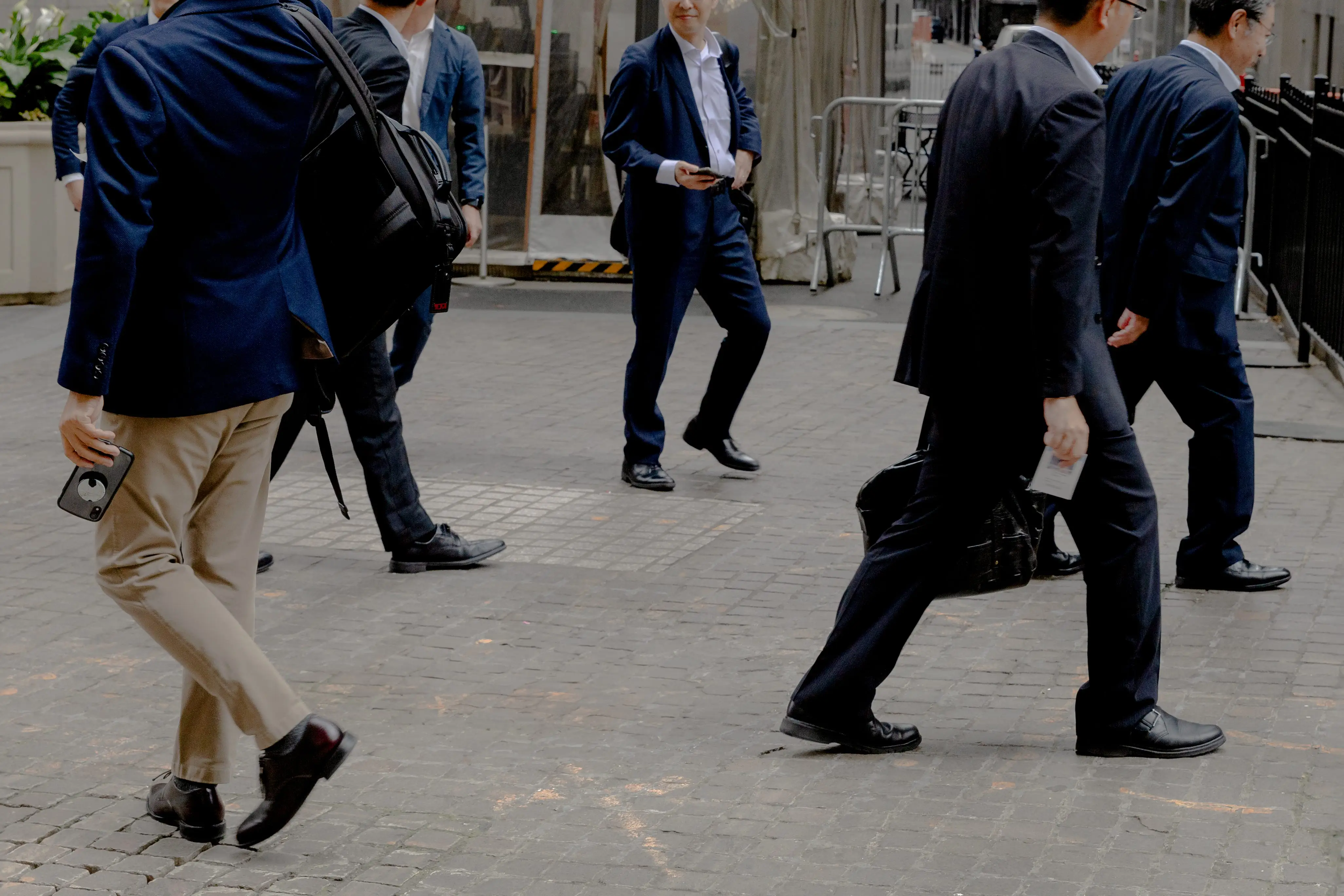 A group of men in suits walking through downtown Manhattan