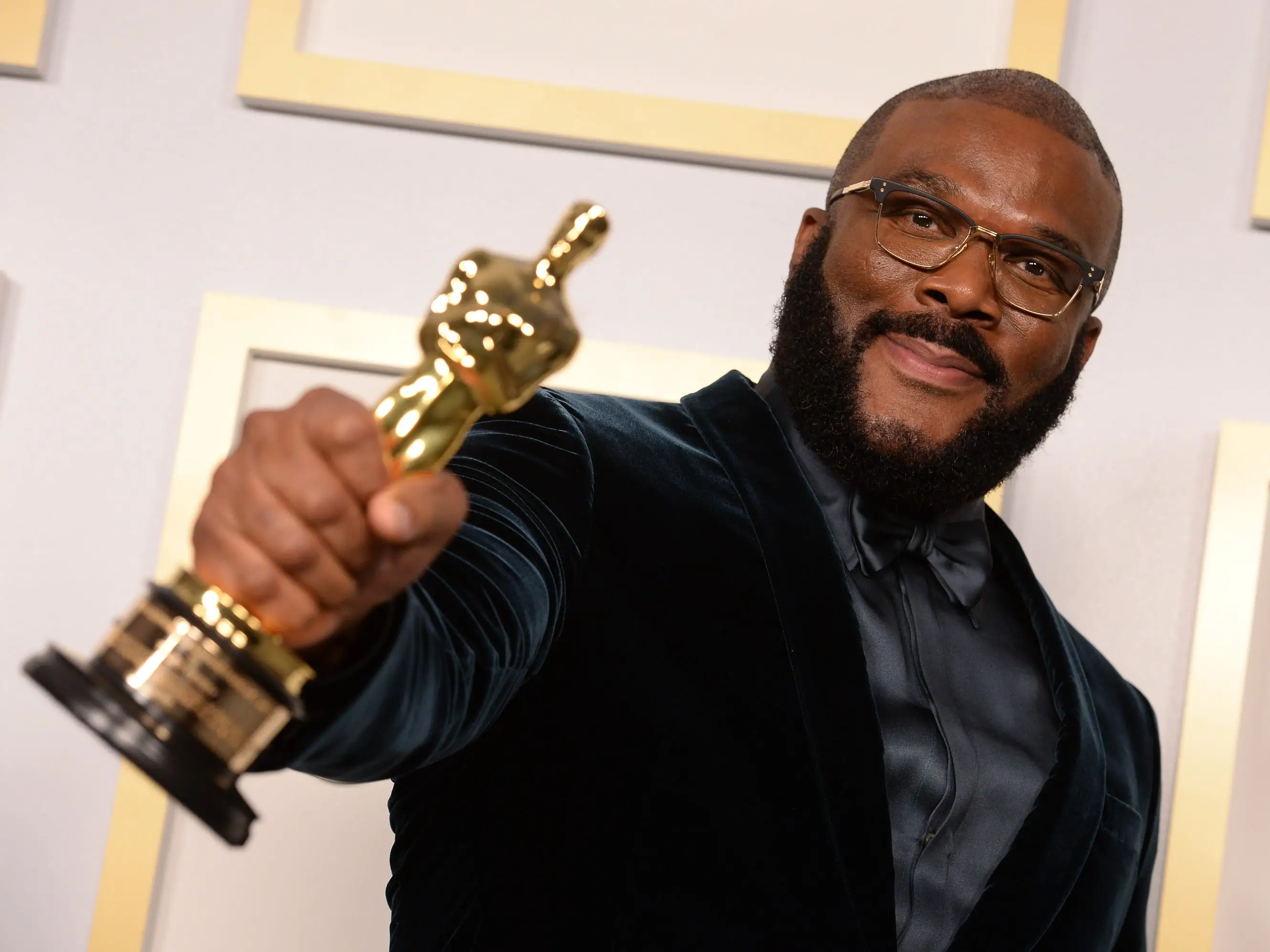 Tyler Perry holding his Oscar statue.