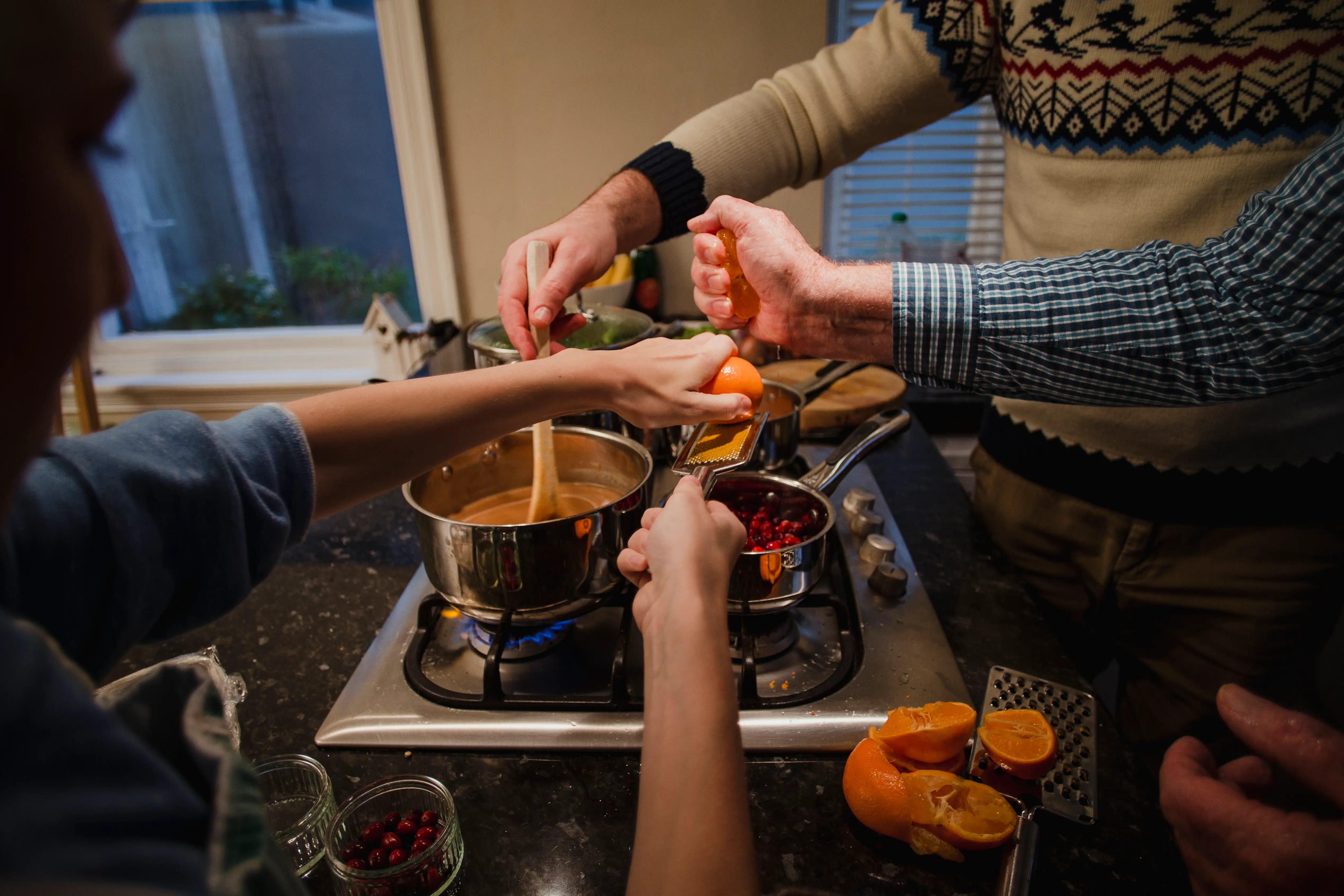 Three people are cooking the same dish