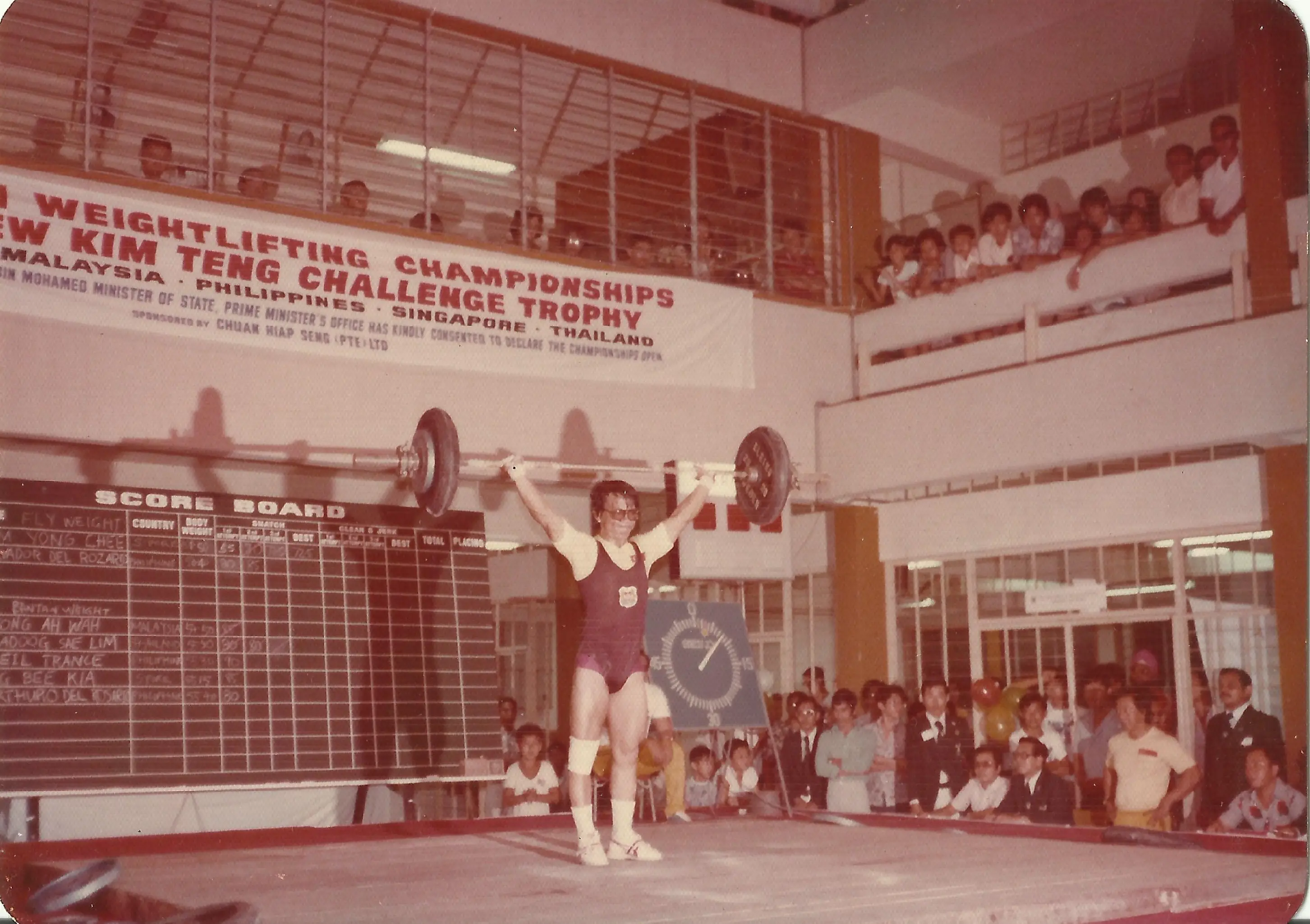 A vintage photo of a man at a weightlifitng competition.