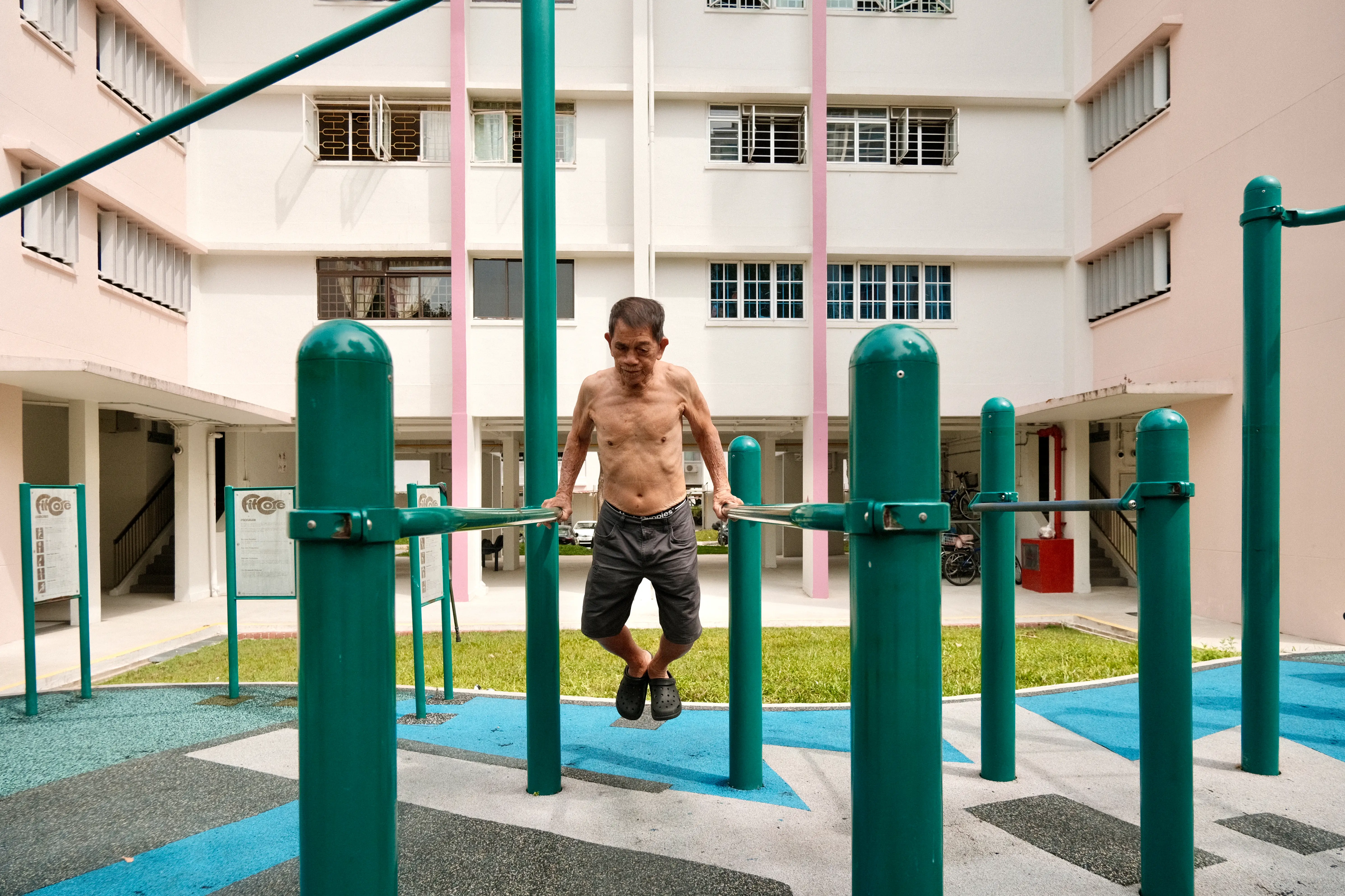 A man working out on a push-up bar in Singapore.