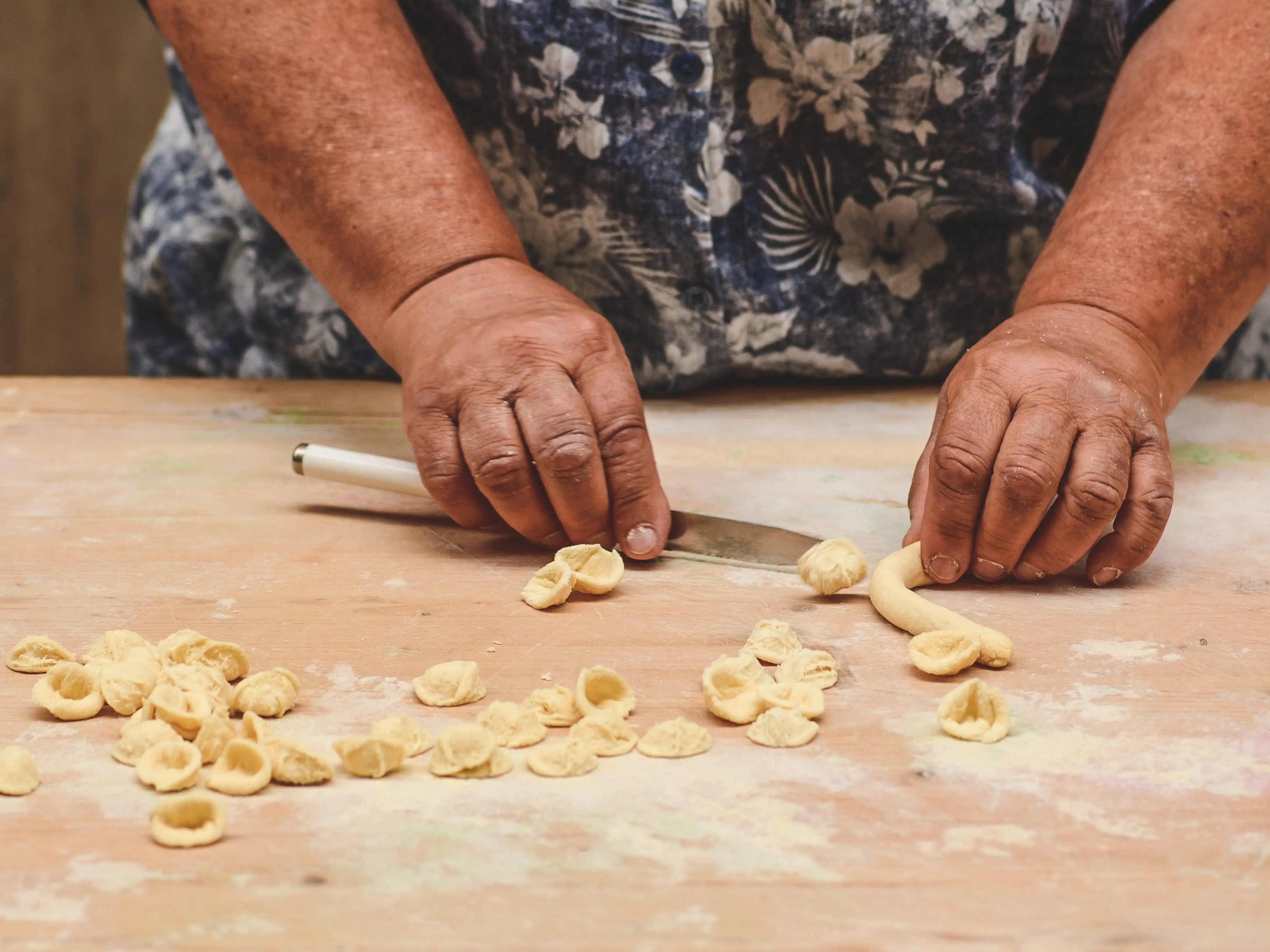 A close-up of a woman's hands making orecchiette in Old Town Bari.