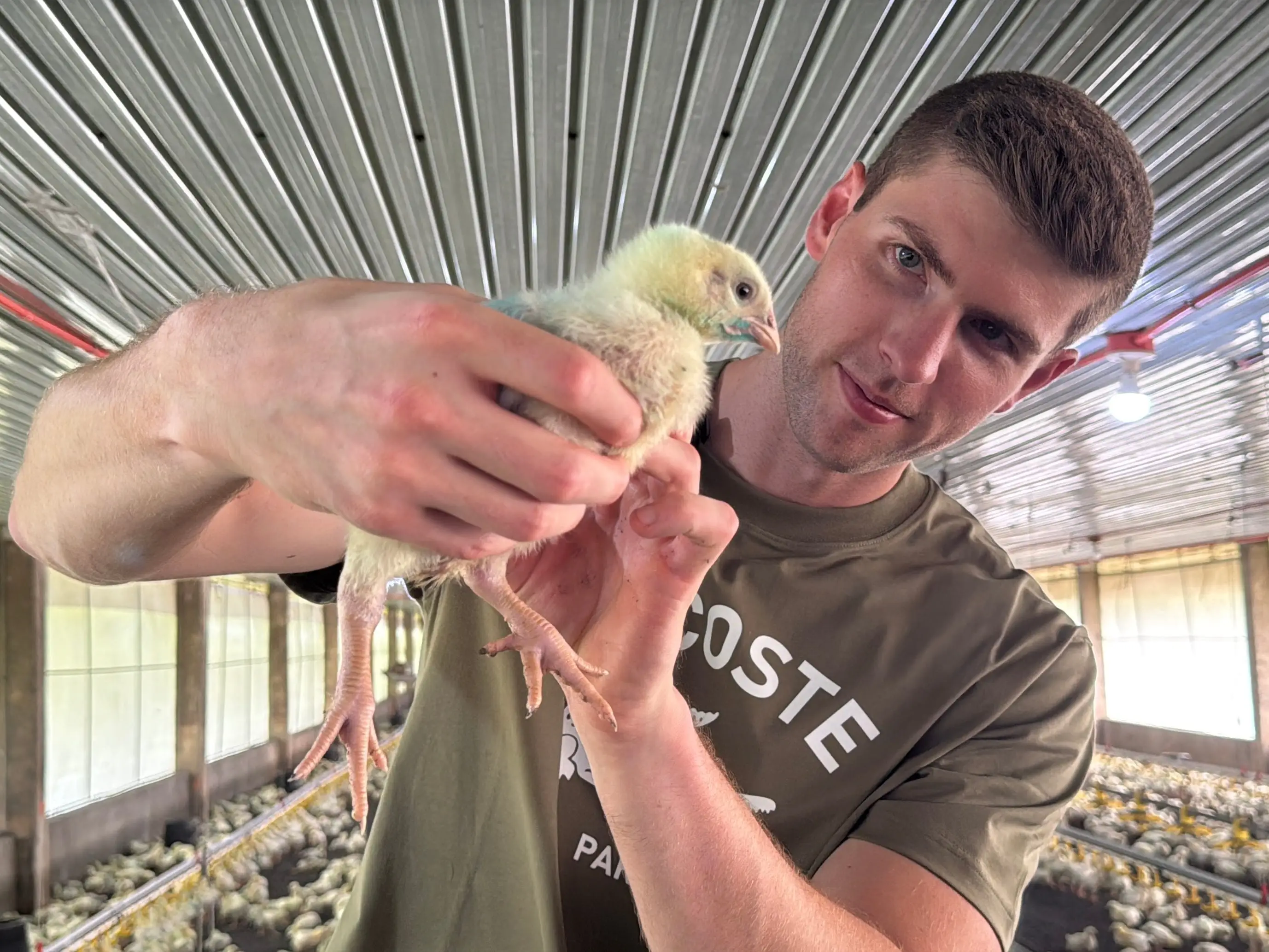 Andrew Fletcher with a chicken in one of his farms in the Philippines.