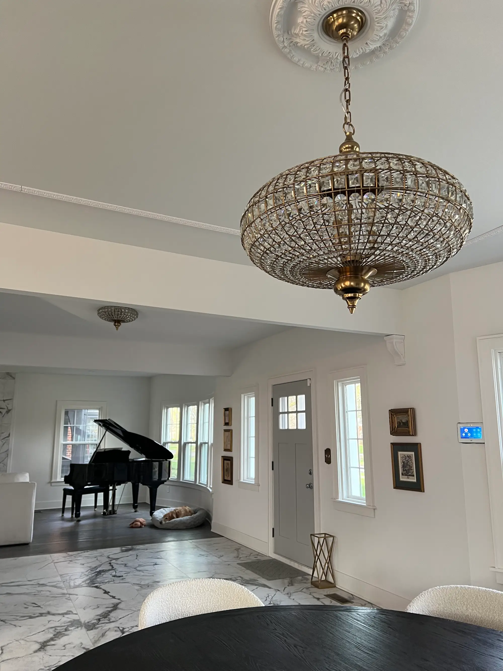 The foyer of a home with marble flooring and tall ceilings.