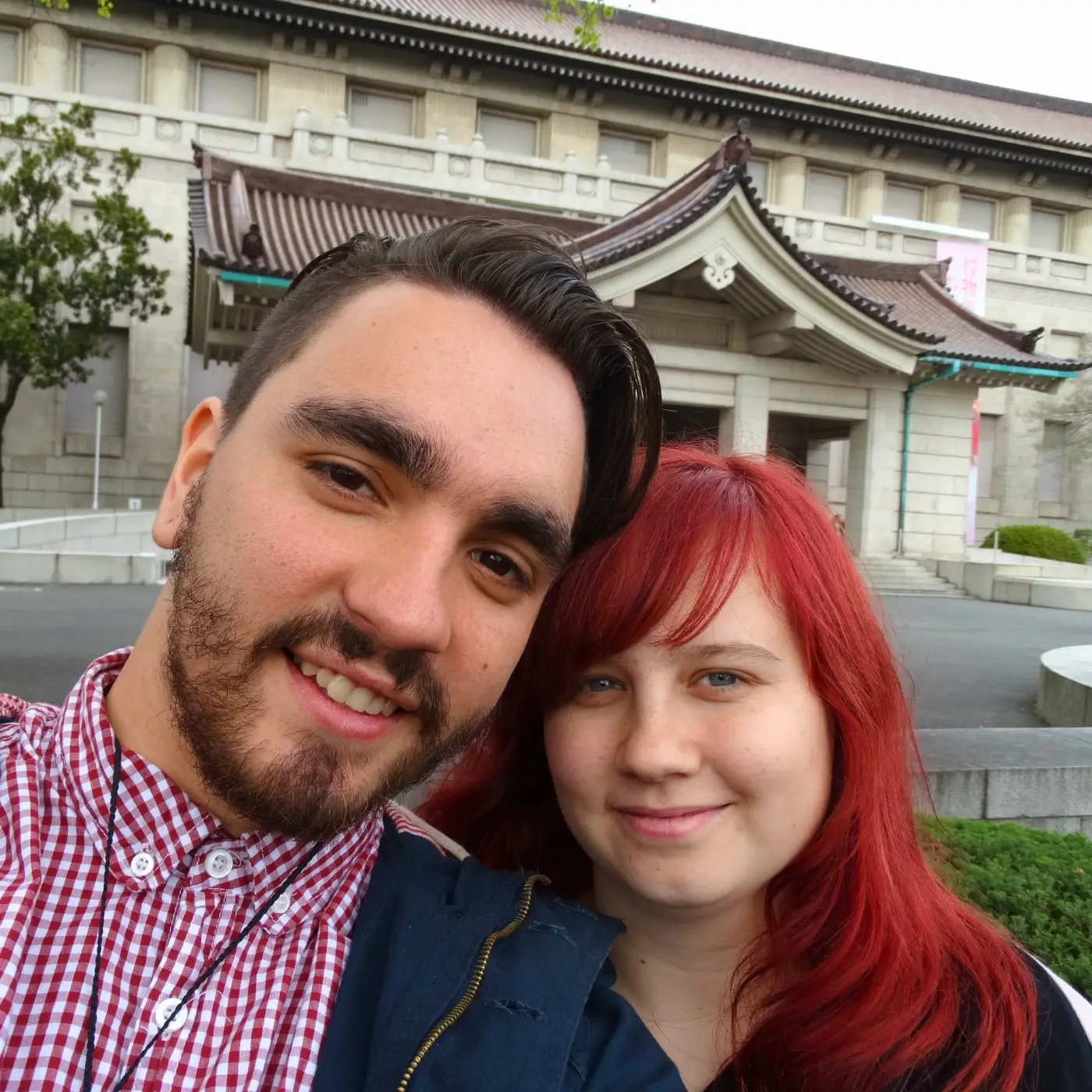 Man and woman smiling in front of temple in Japan
