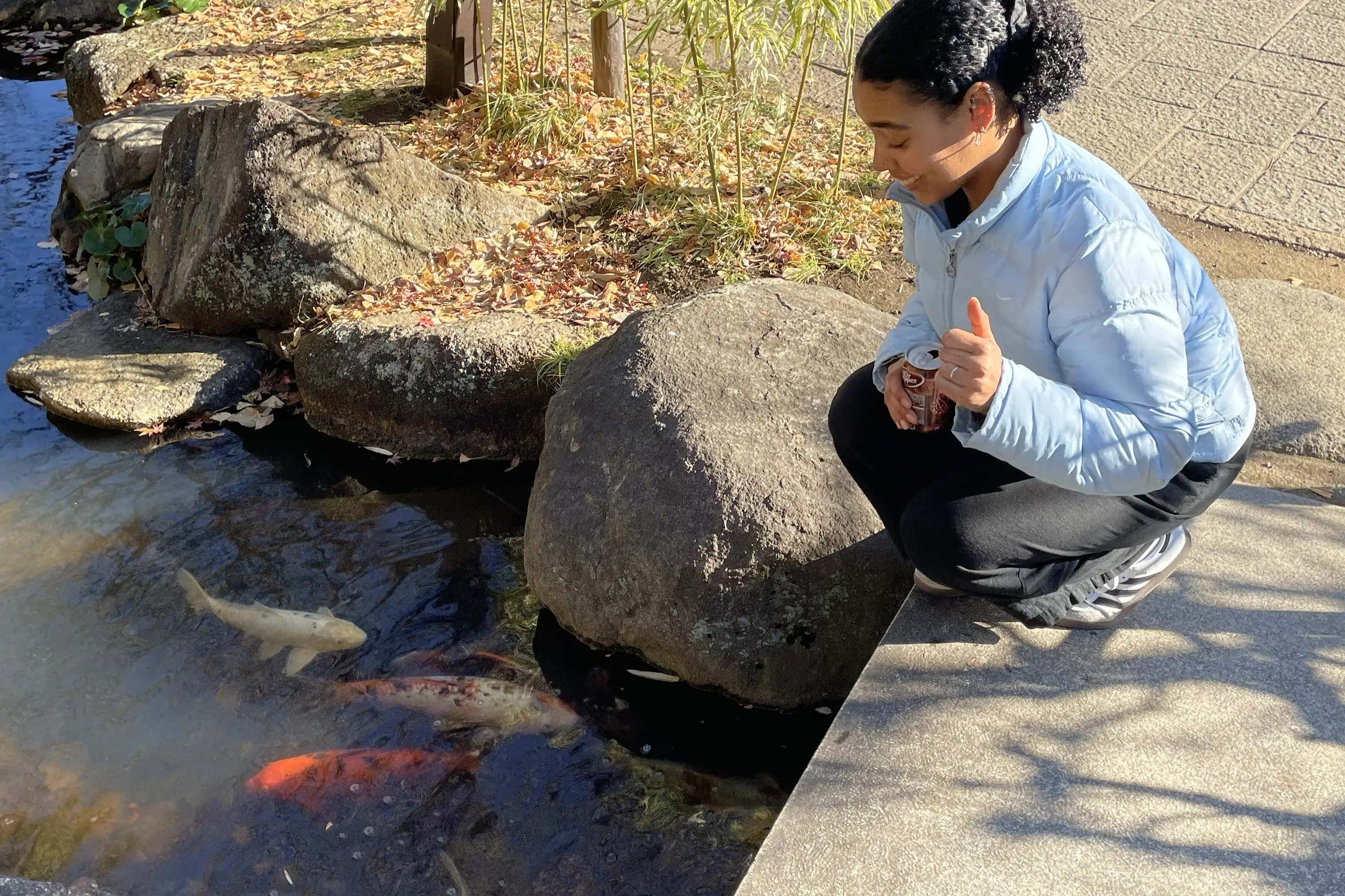 Woman smiling near koi pond