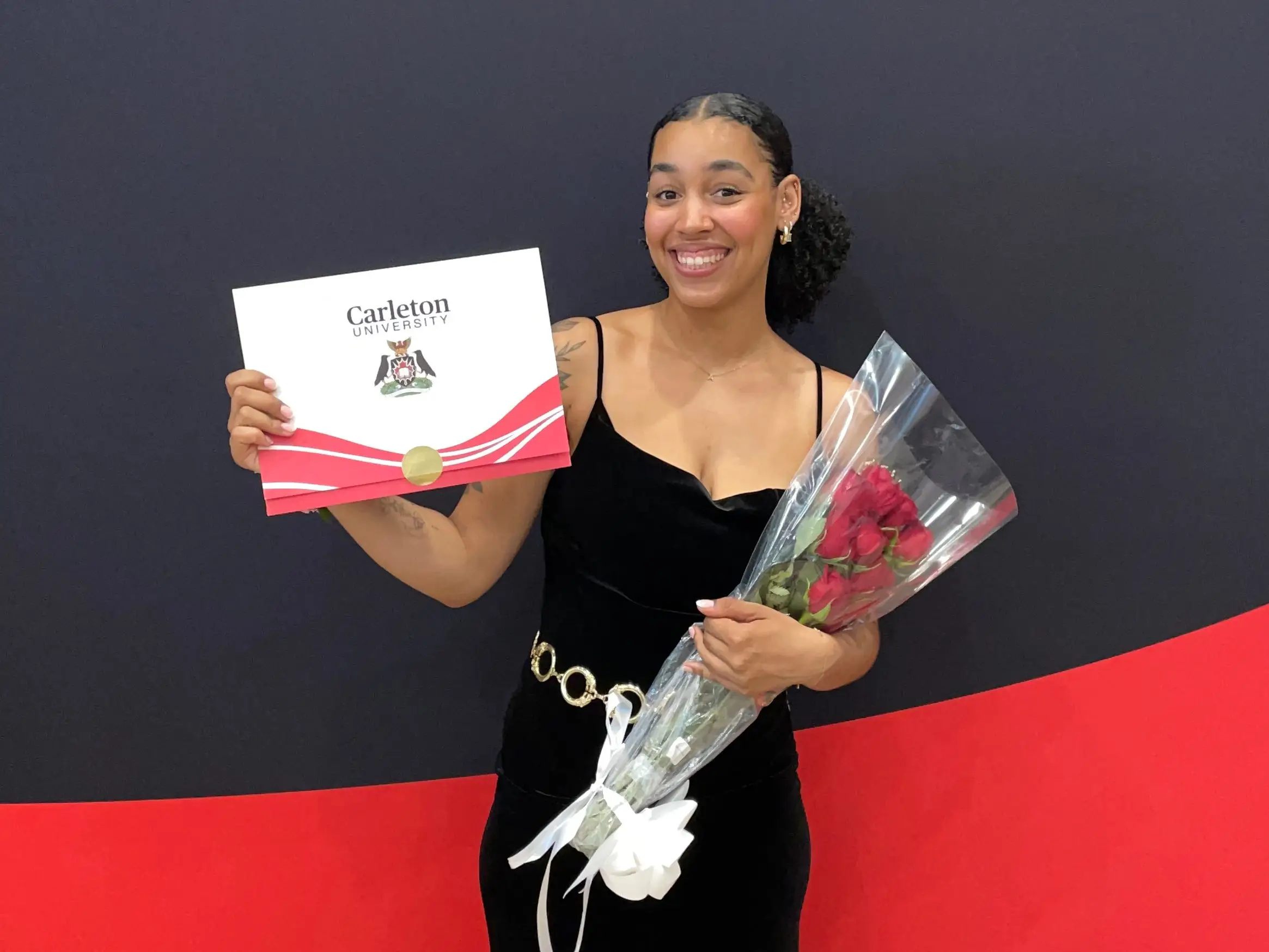 Womam smiling with flowers, diploma