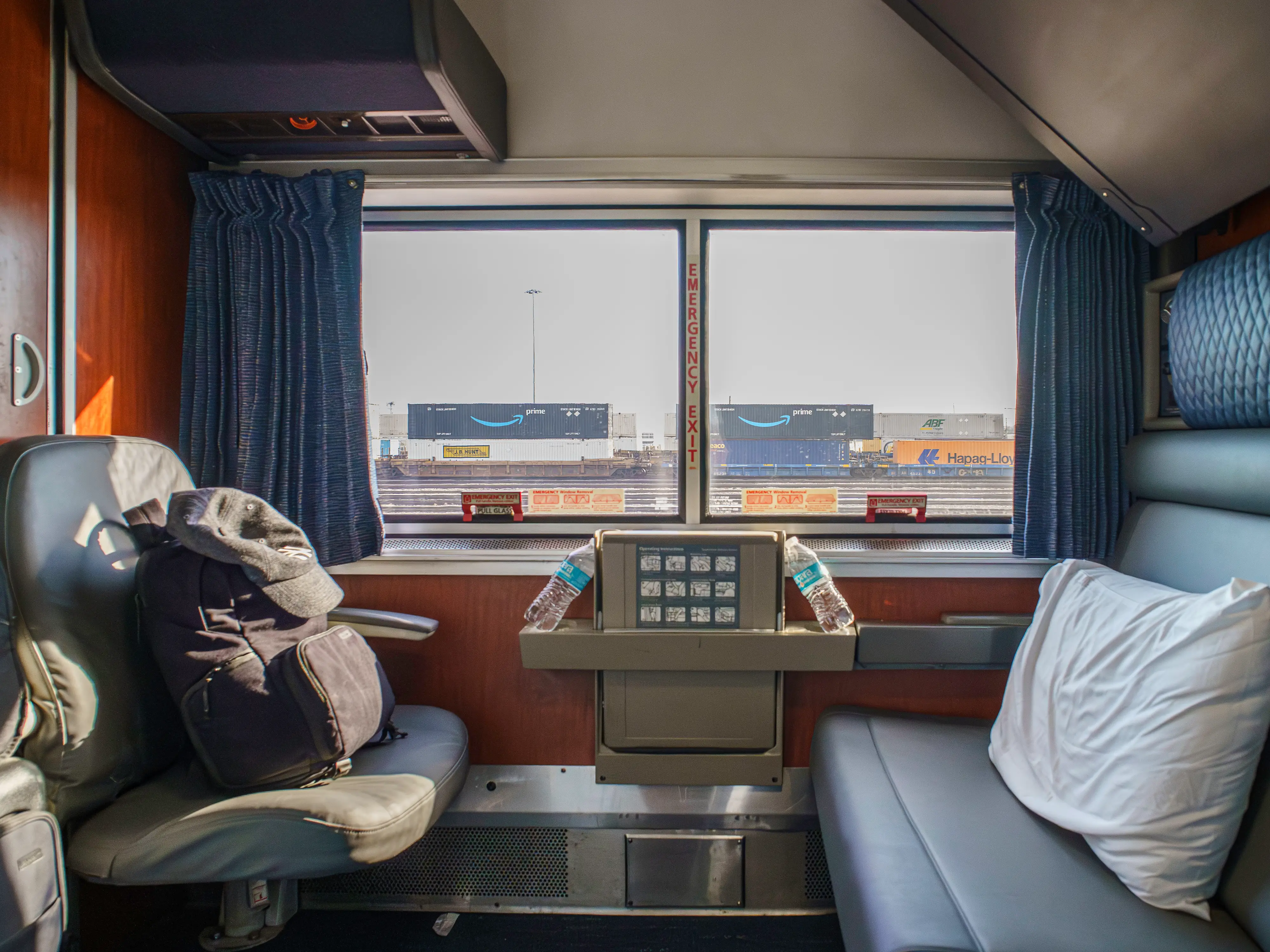 Inside an Amtrak bedroom with two seats across from eachother in front of a wide window