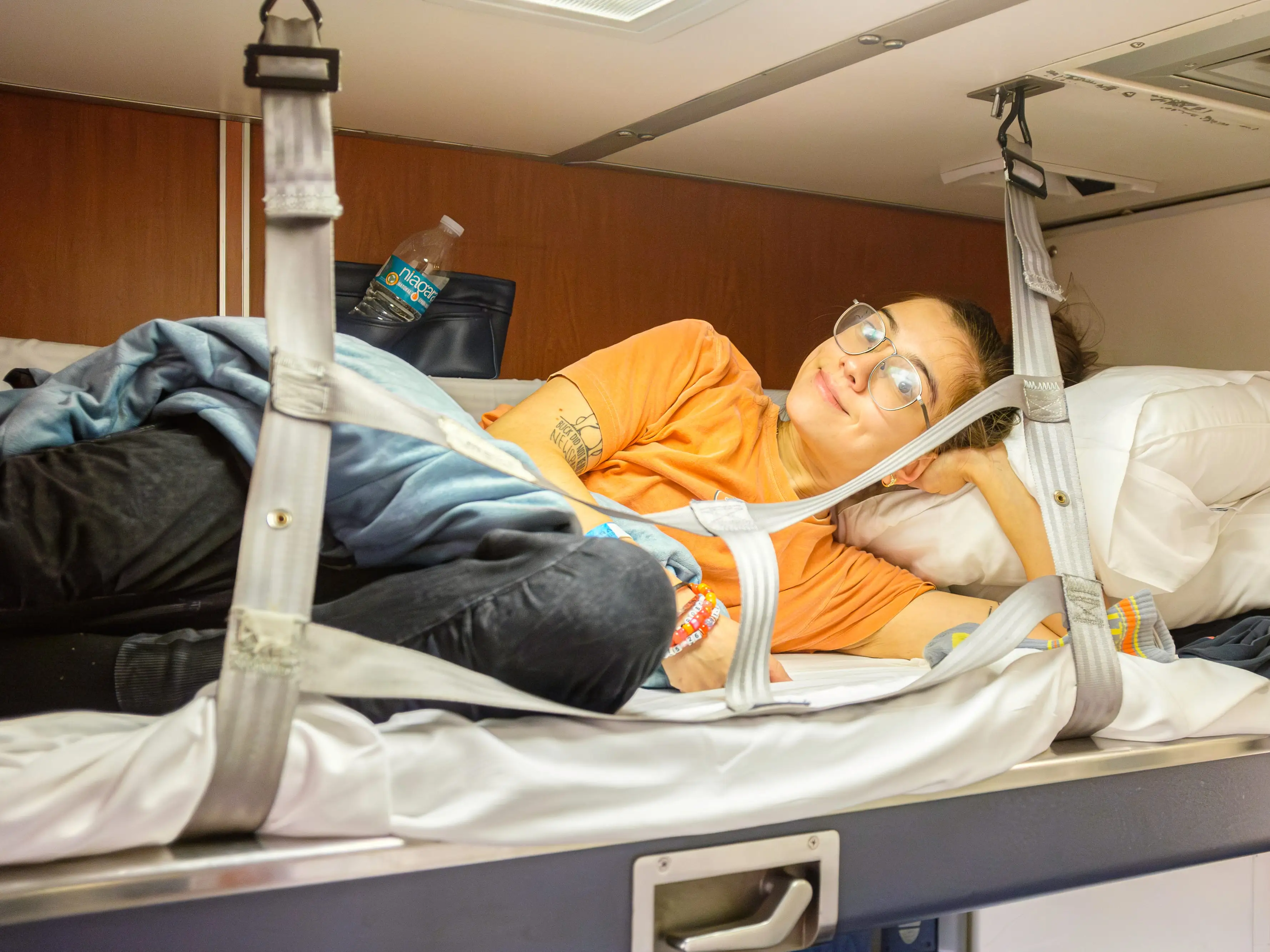 The author lies smiling in the top bunk in the Amtrak bedroom