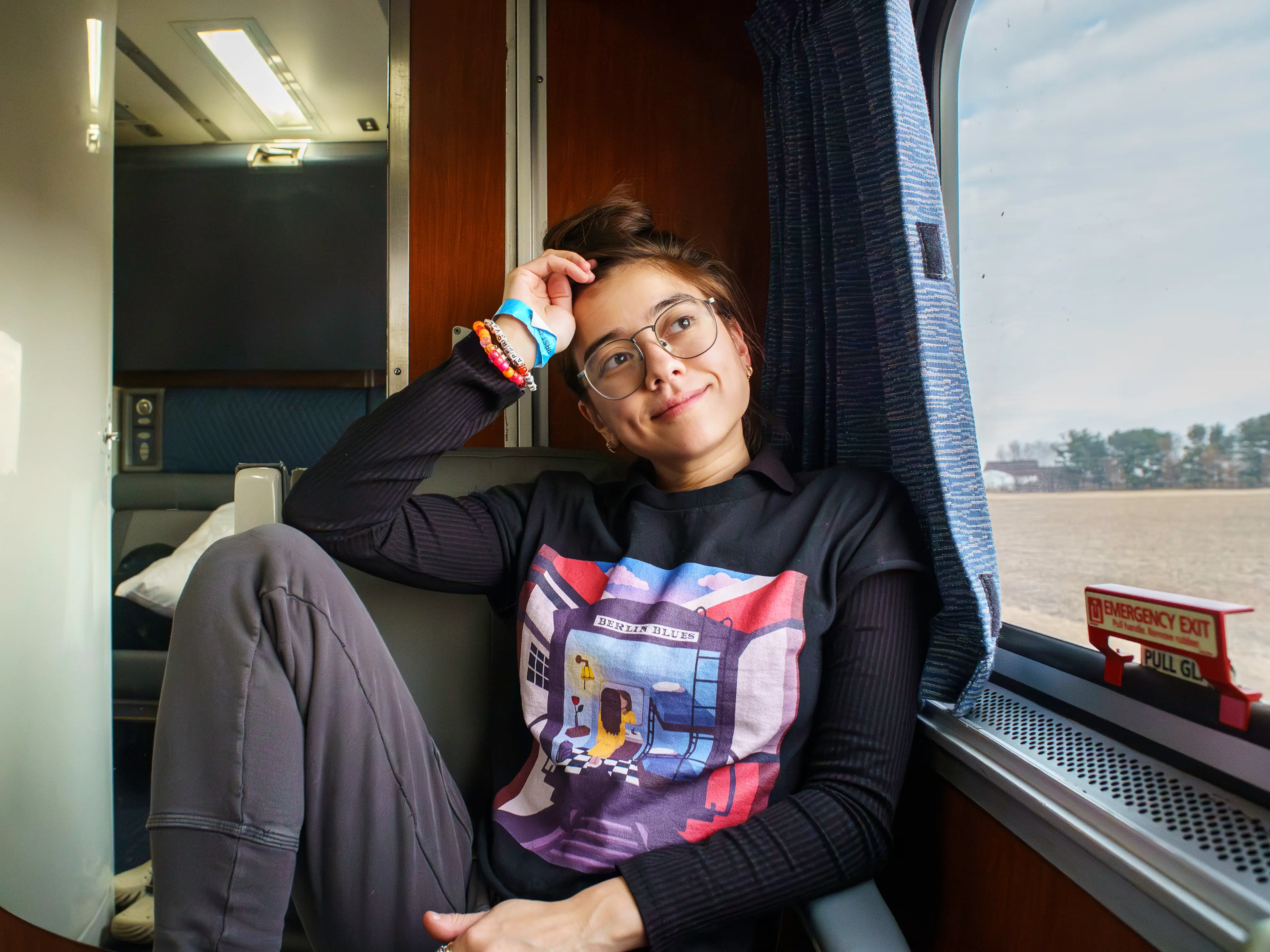 The author sits looking out a window to the right in the Amtrak bedroom
