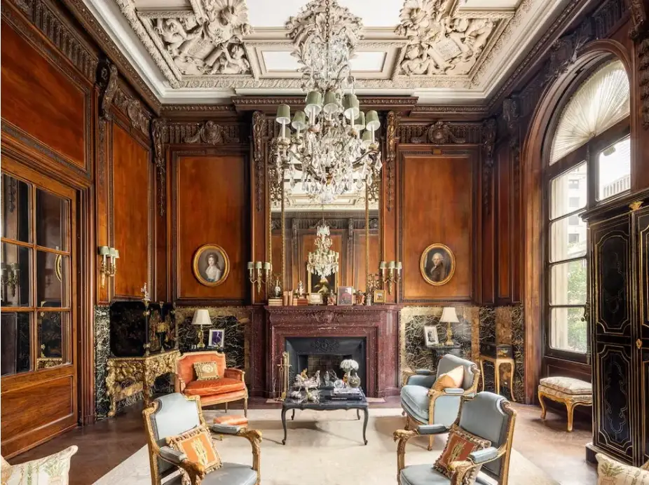 The library of House of Cassini features 17-foot ceilings bedecked by plaster sculptures of owls, urns, and cherubs.