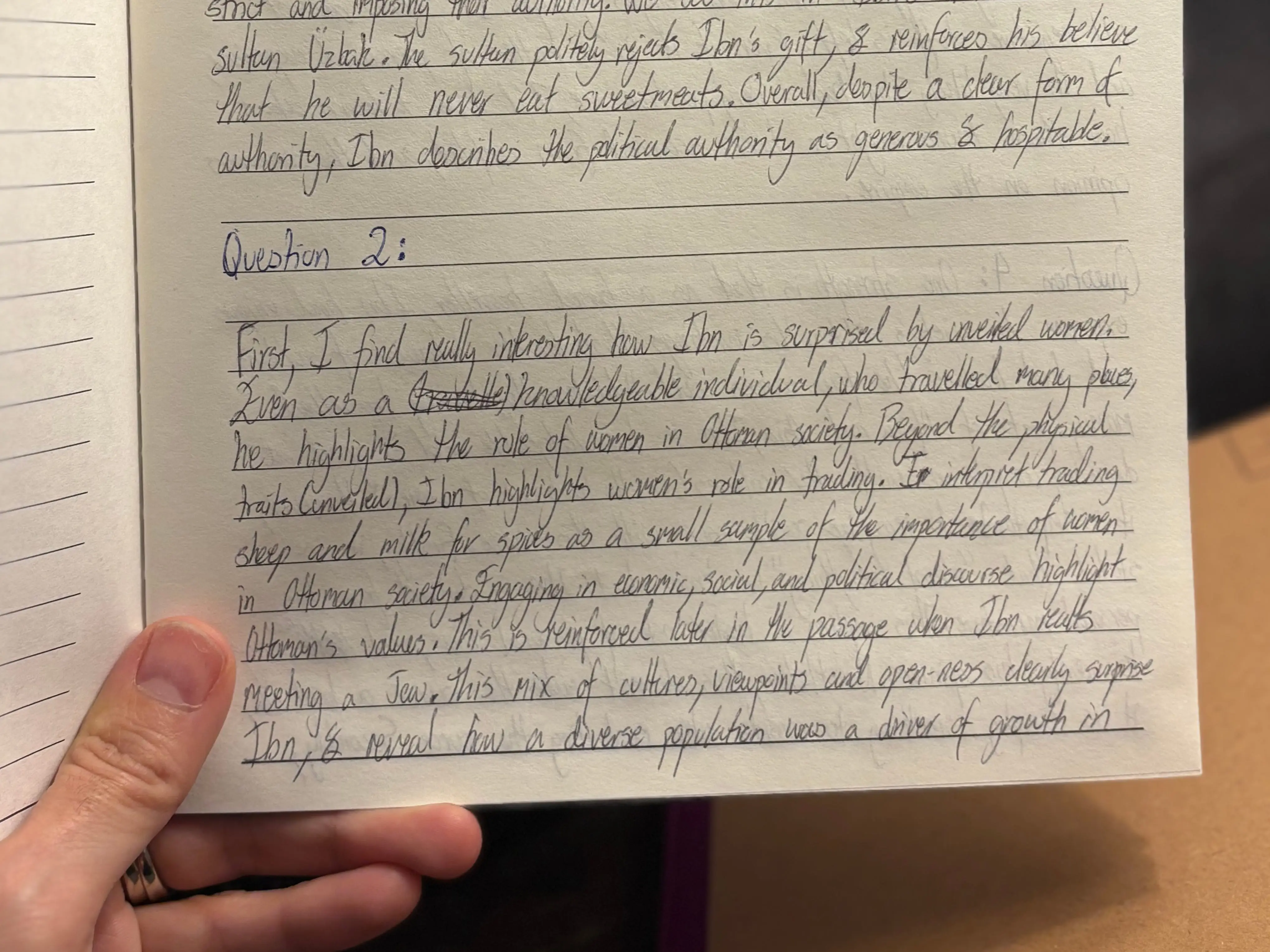 Notebook for history assignment at NYU is held in a hand.