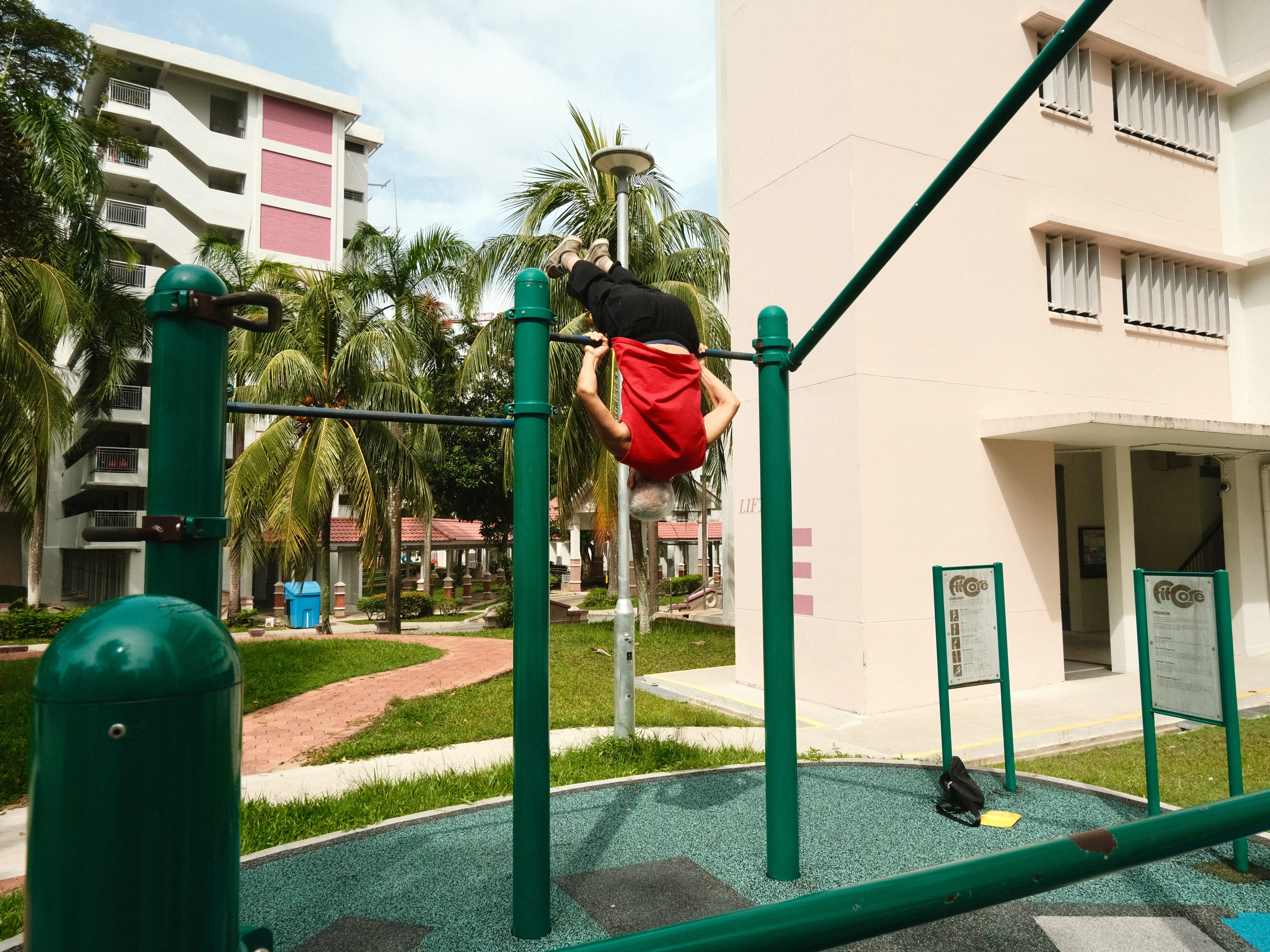 Man doing flips on a pull-up bar.