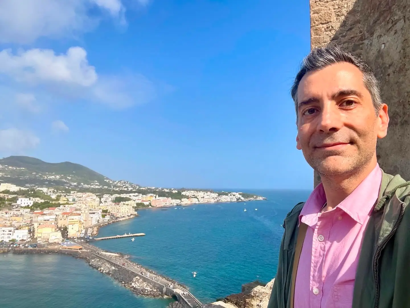 Mark Marino (author) taking selfie in Ischia, Italy with coast behind him