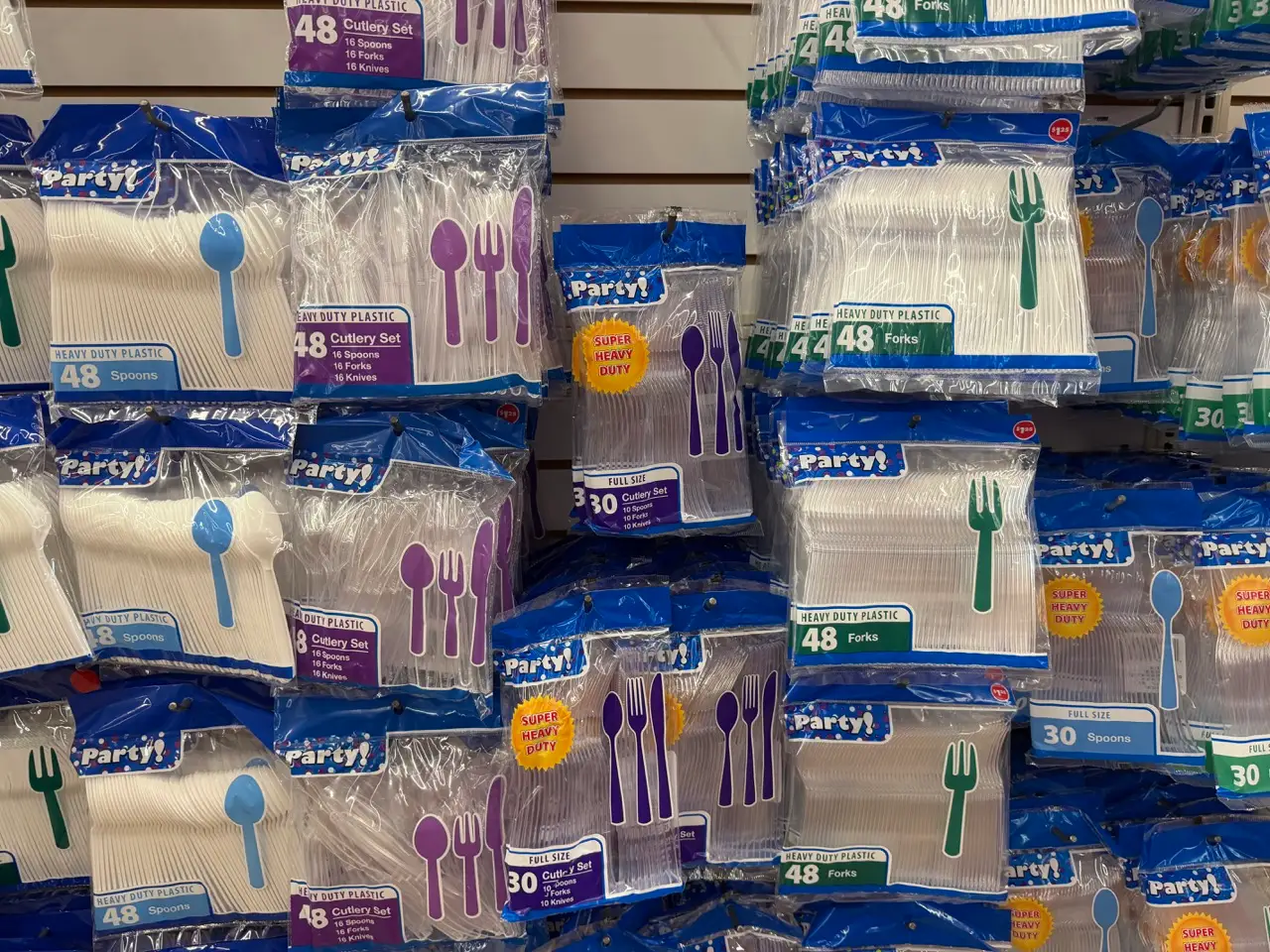 Plastic cutlery in bags in aisle at Dollar Tree