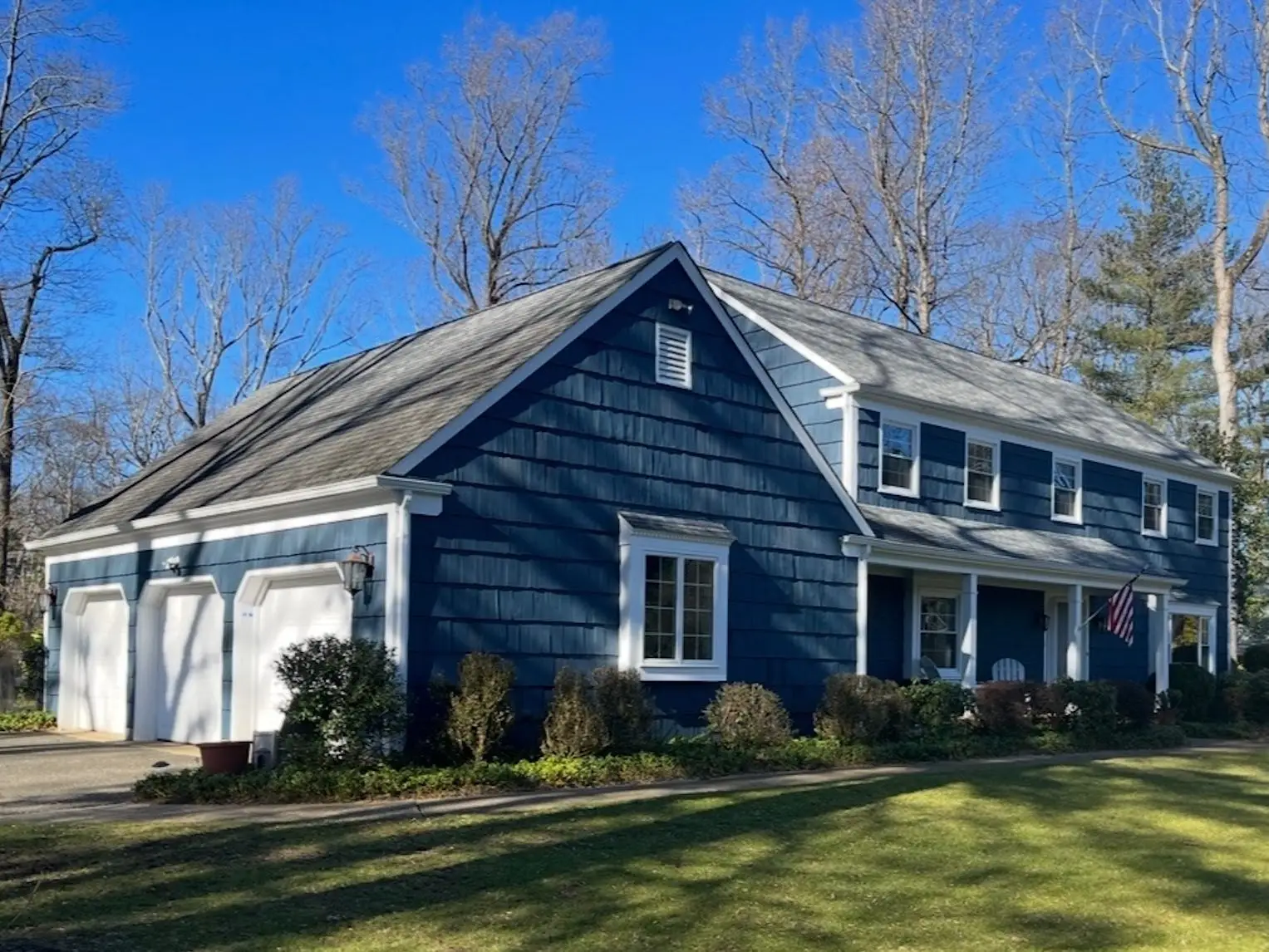 A blue house with a three-car garage.