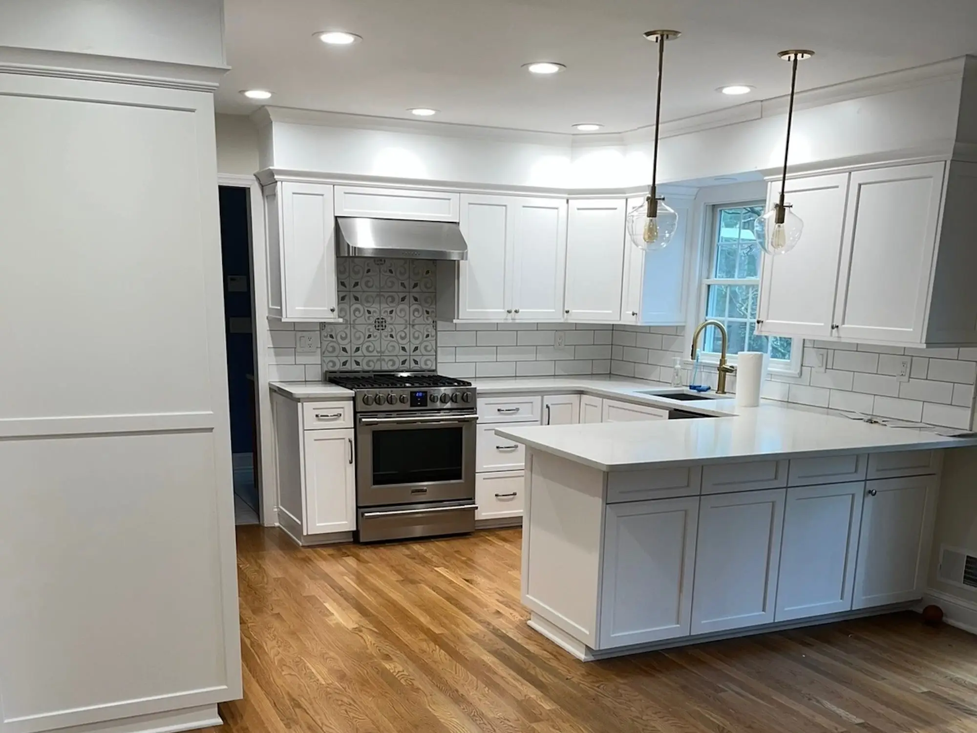 A kitchen with white cabinetry and silver appliances.