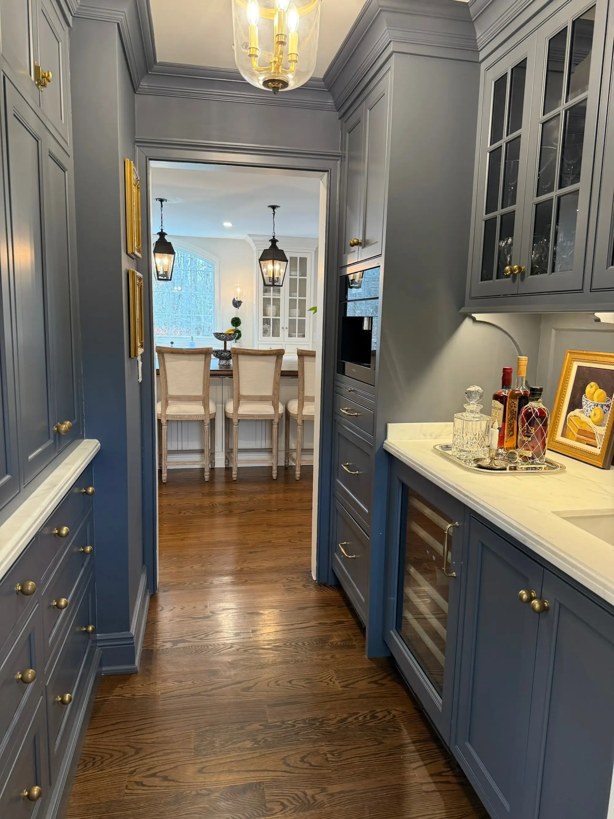 A blue butler's pantry with a wine refrigerator and built-in cabinetry.