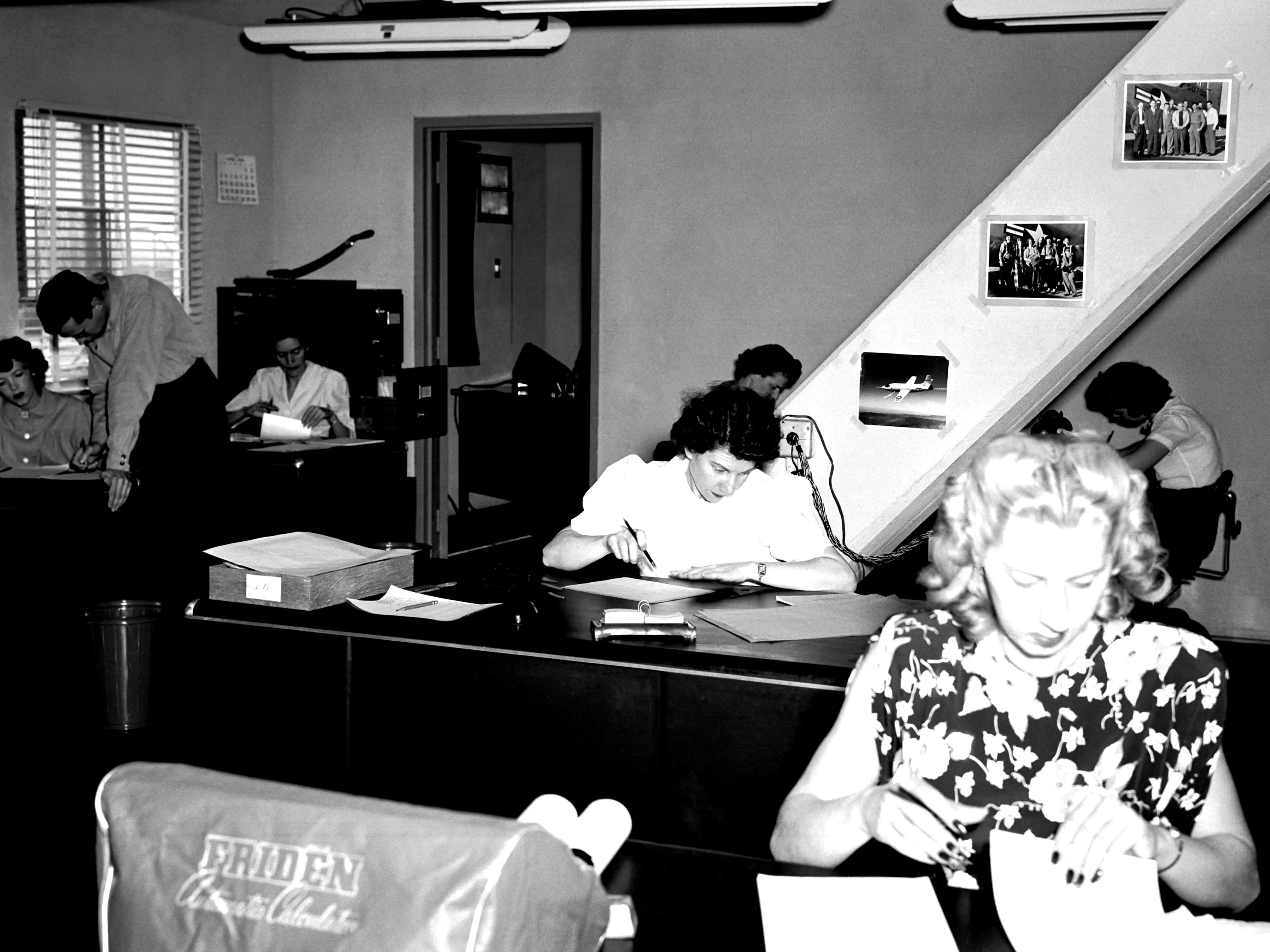 People computing numbers with pen and paper.