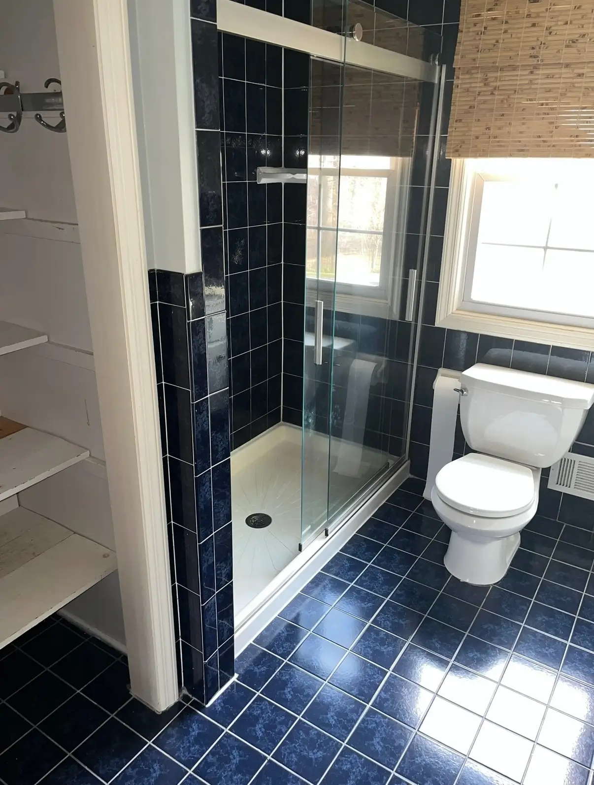 A bathroom with blue tile floors and walls.