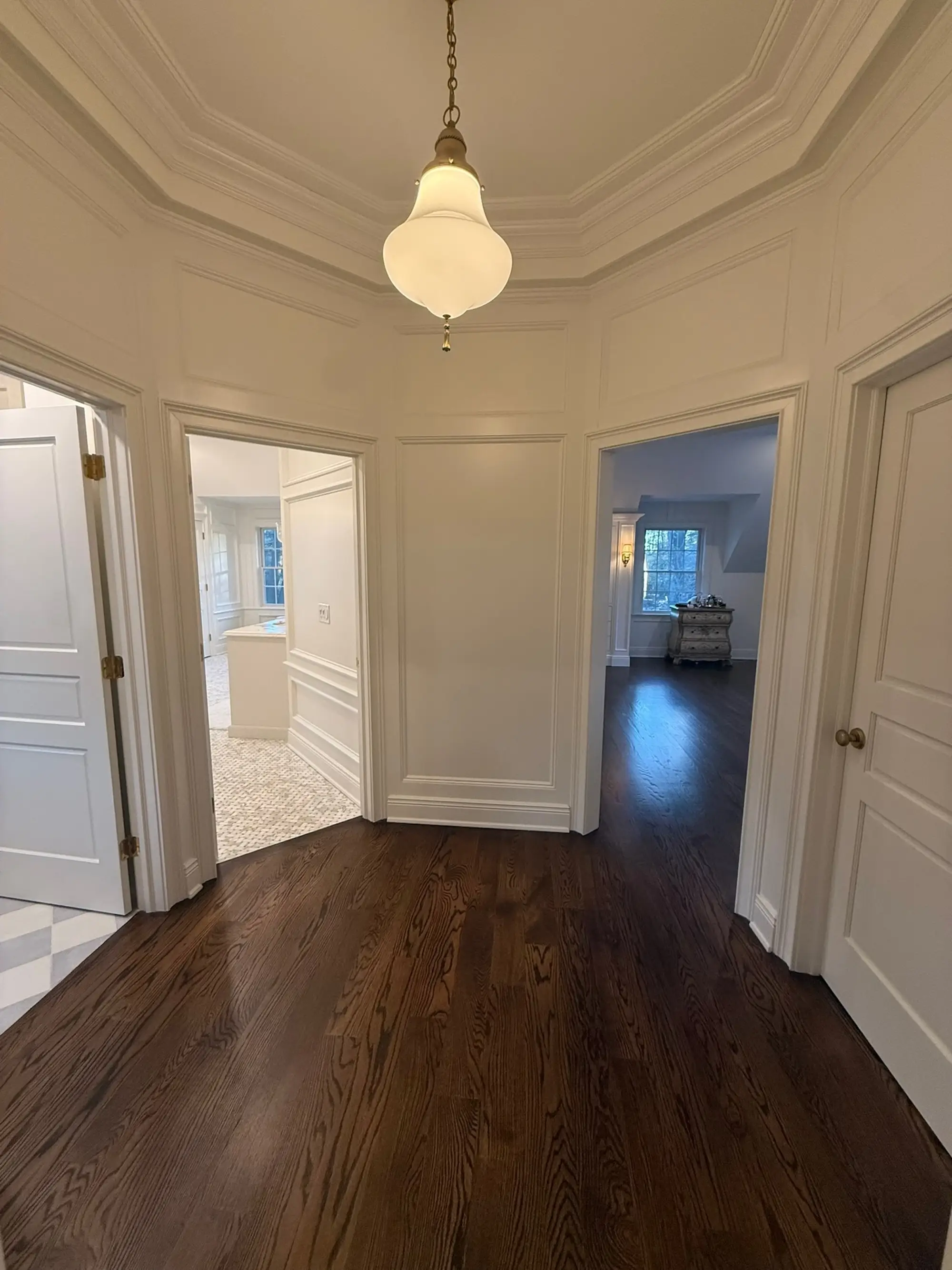 A hallway with multiple rooms off of it.