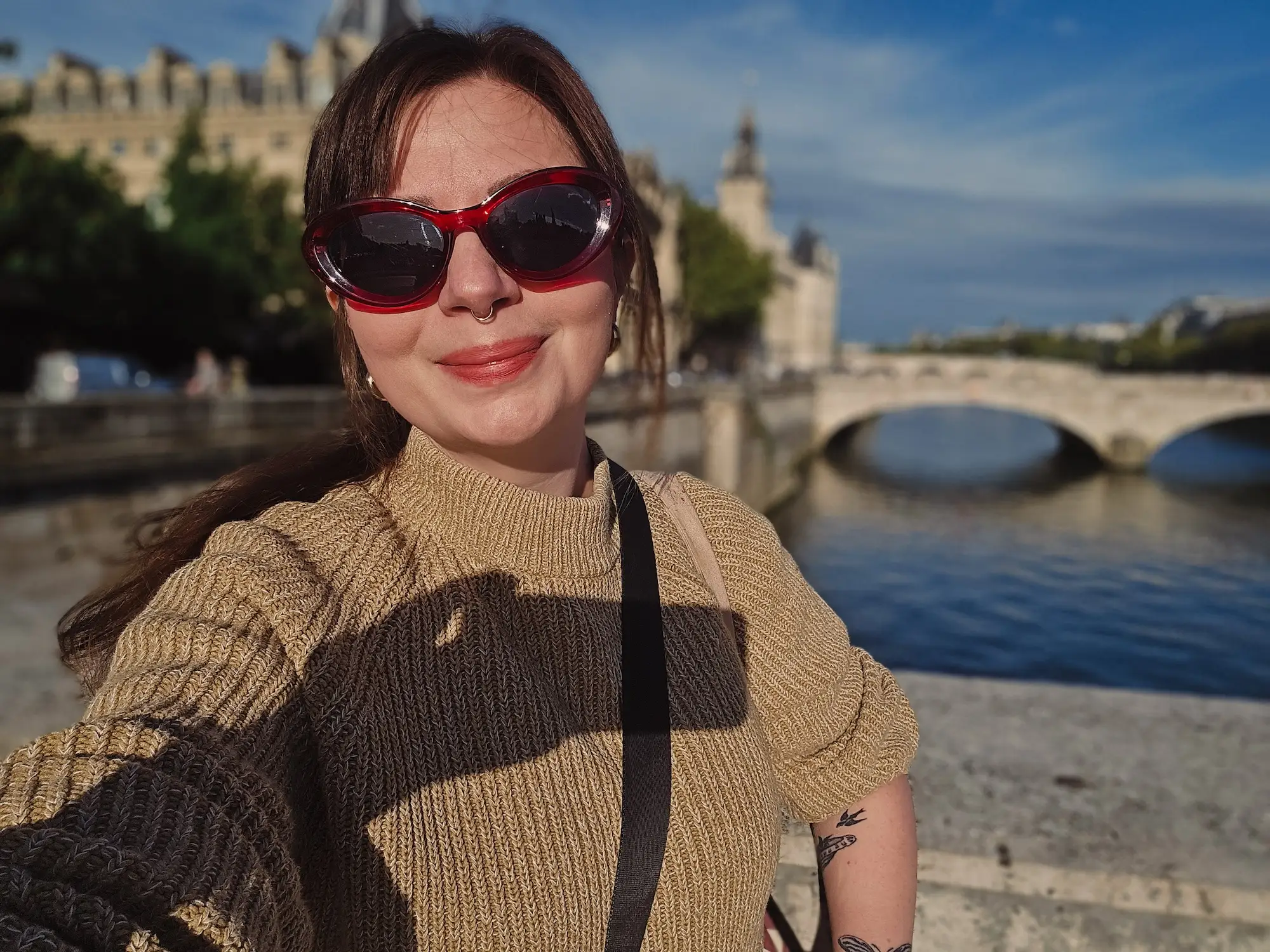 A woman poses on the banks of the Seine River.